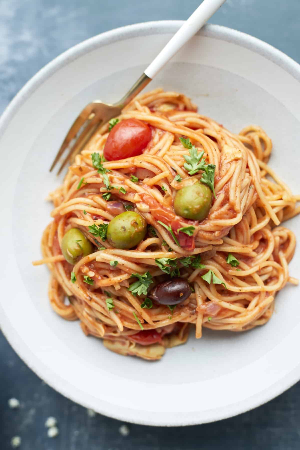 a serving of Greek spaghetti on a white plate with a fork