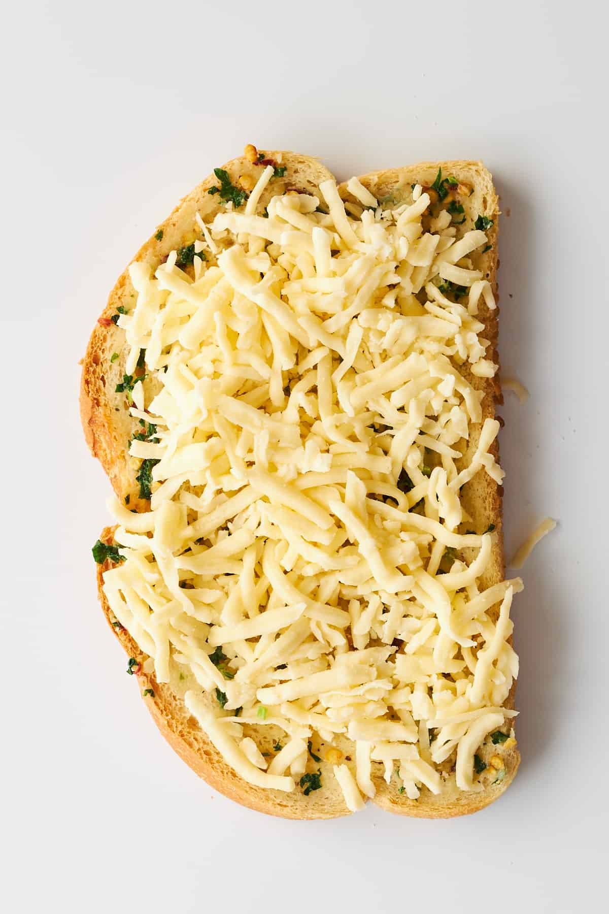 Herbed butter and mozzarella cheese on a slice of bread.