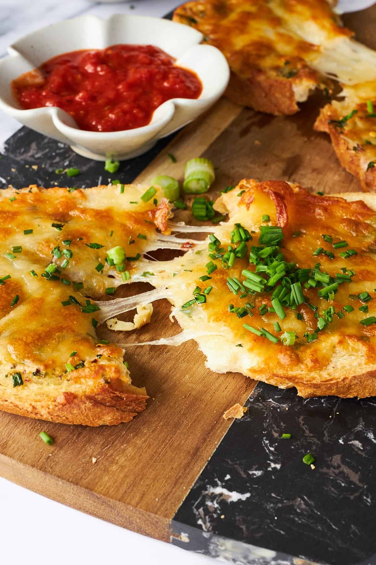 Cheesy garlic toast being pulled apart.