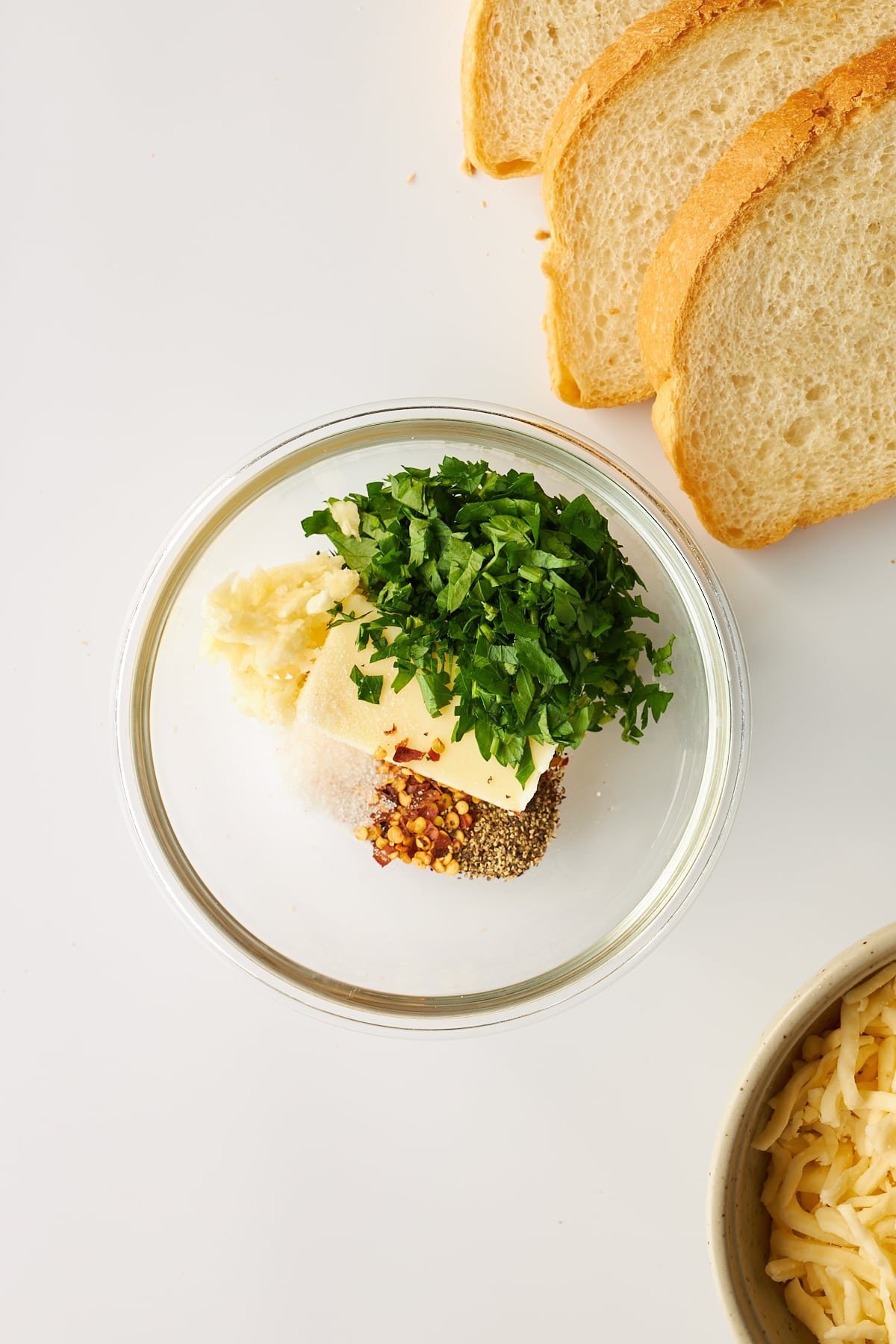 Butter, garlic, parsley, and seasonings in a bowl.