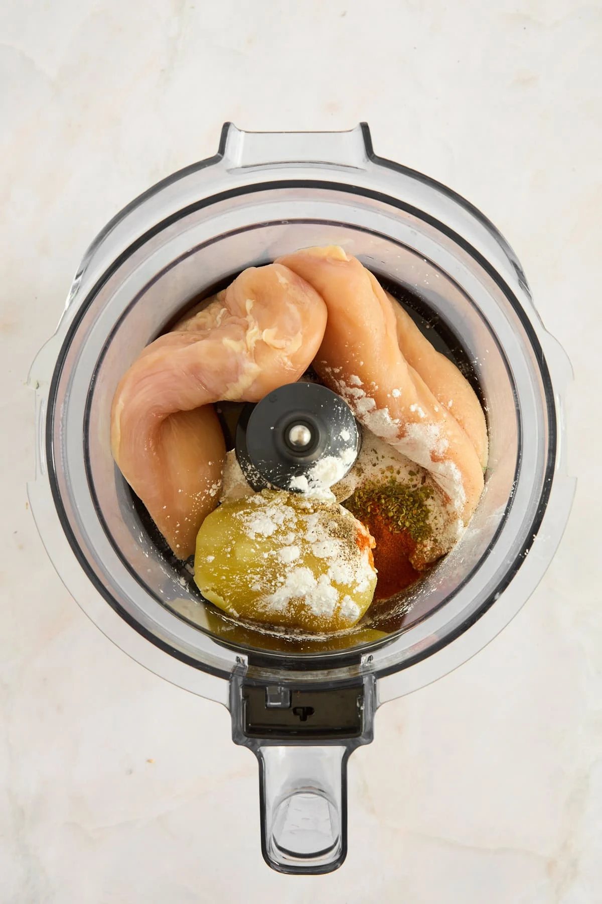 Ingredients to make chicken nuggets in a food processor.