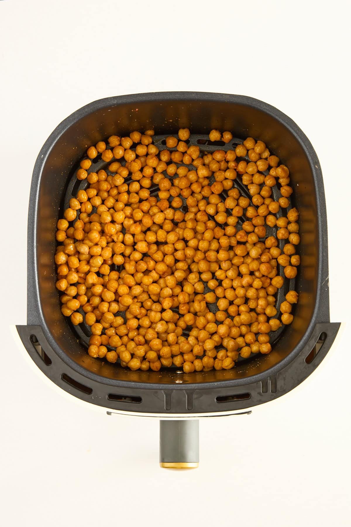 Crispy chickpeas in an air fryer basket.