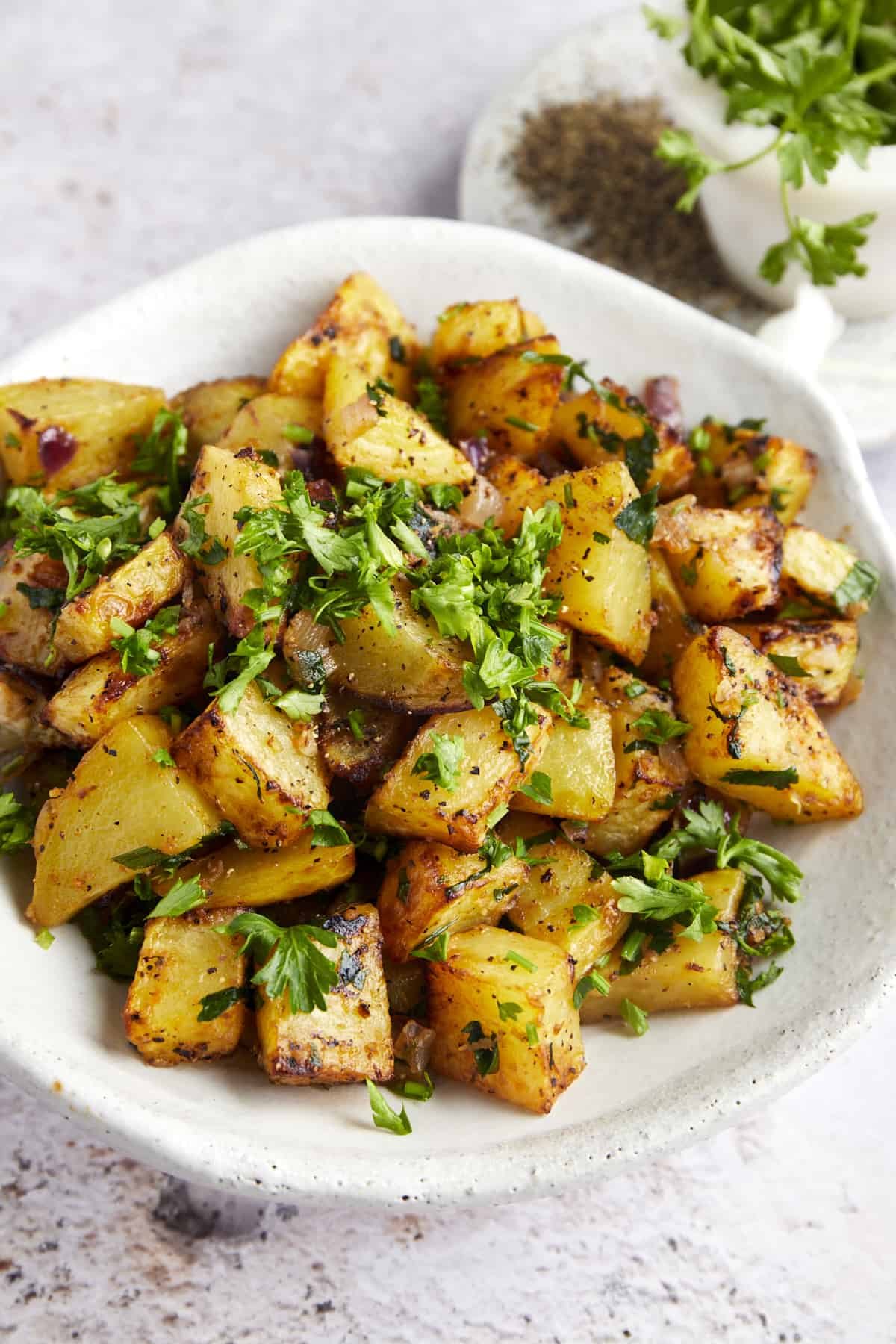 A platter of air fryer golden potatoes topped with fresh parsley.
