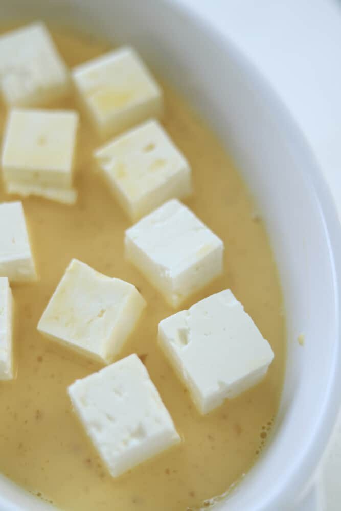 feta cubes in an egg wash