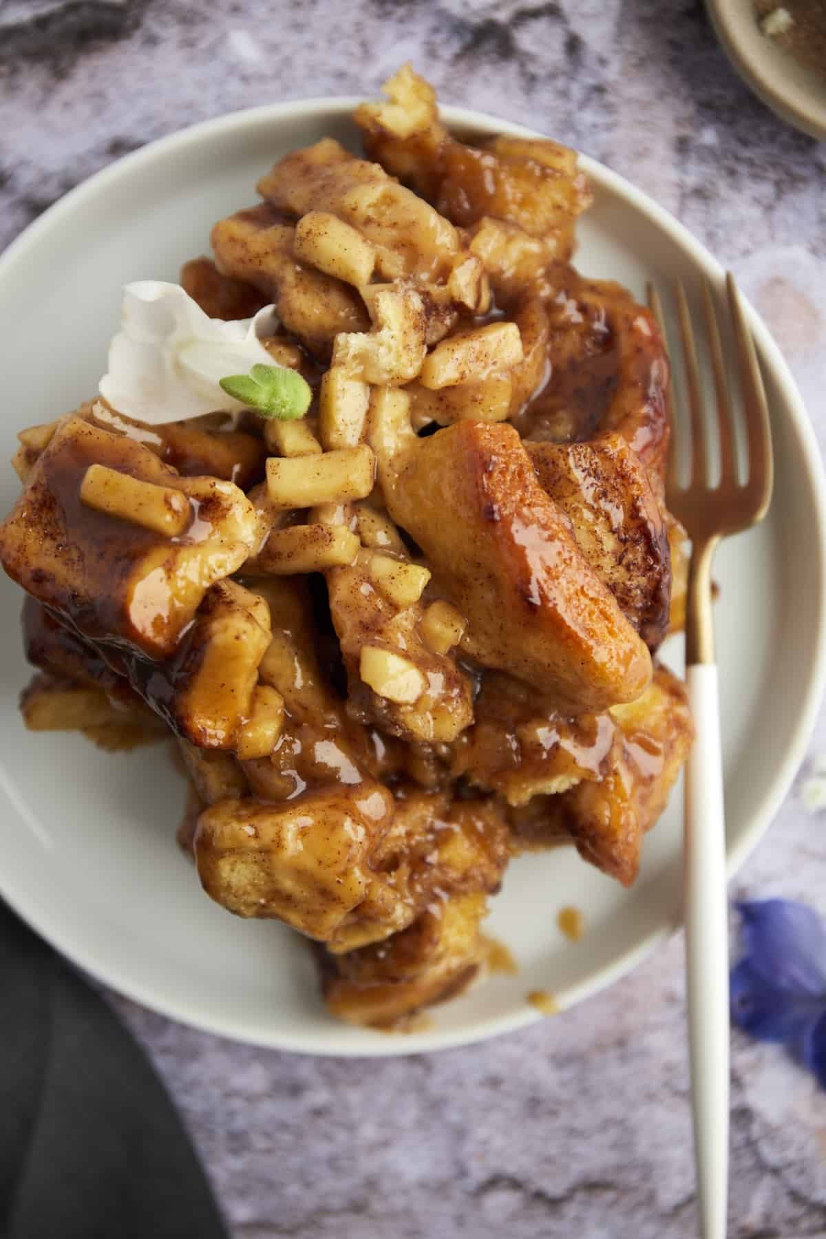apple caramel cinnamon rolls on a plate with a fork