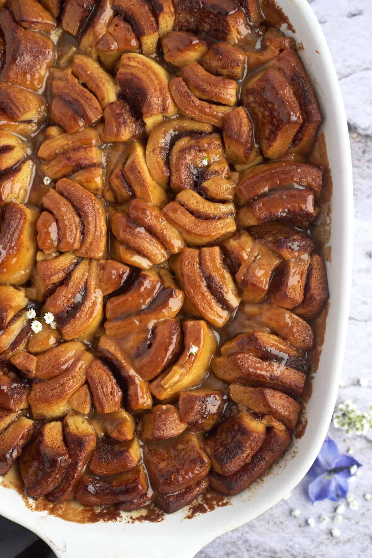 overhead image of a dish full of layered baked apple caramel cinnamon rolls