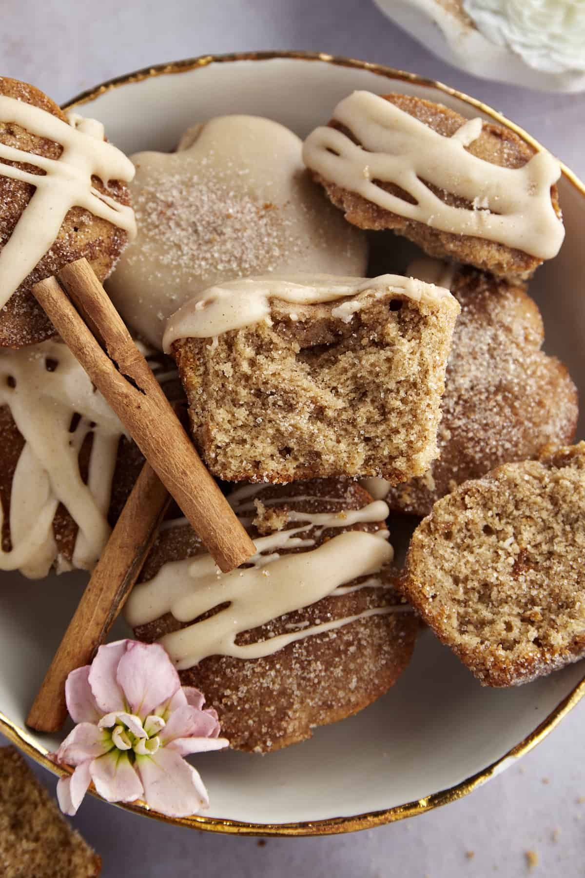 A bowl of apple cider muffins with one split in half.