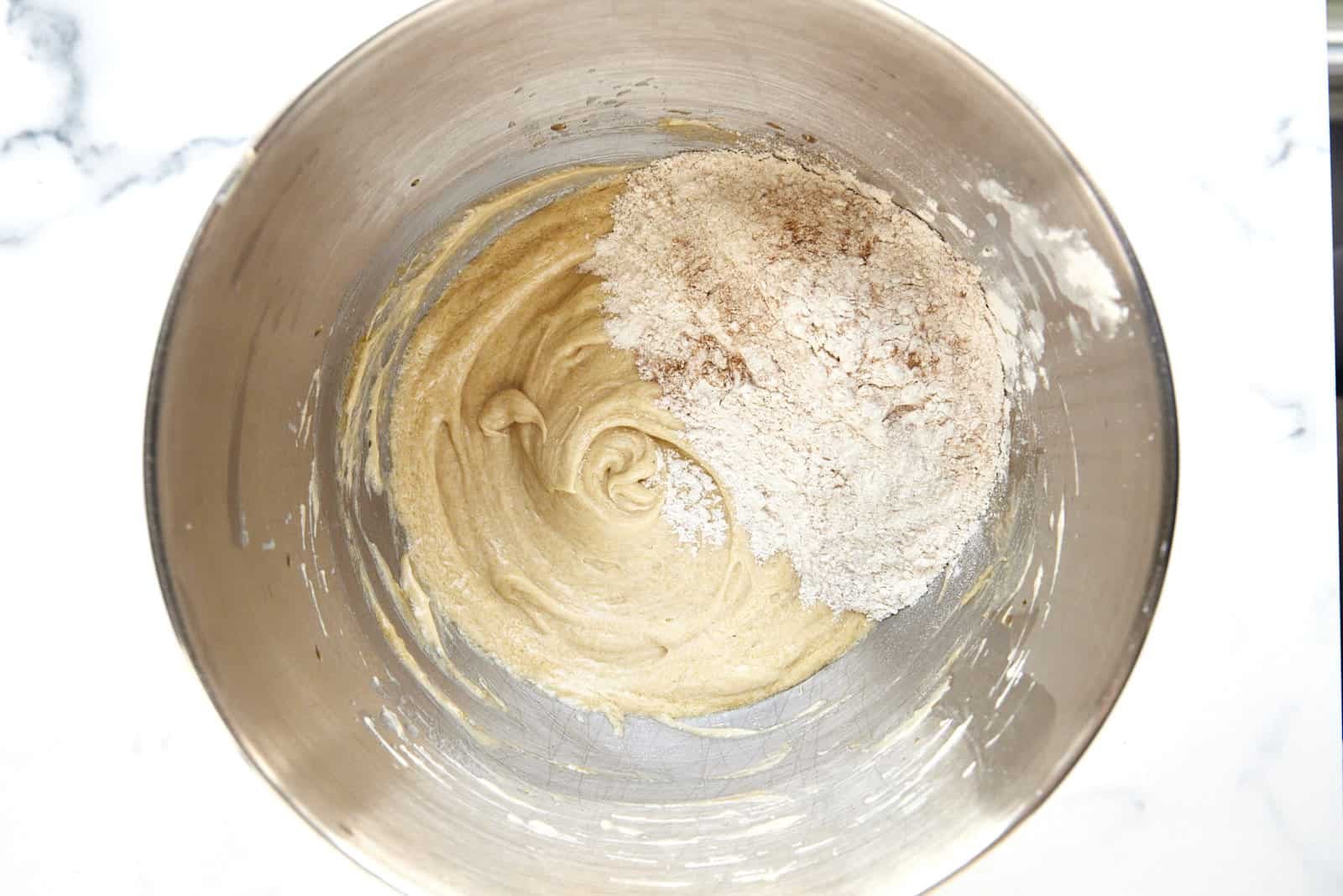 Wet and dry ingredients for muffins being combined in a bowl.
