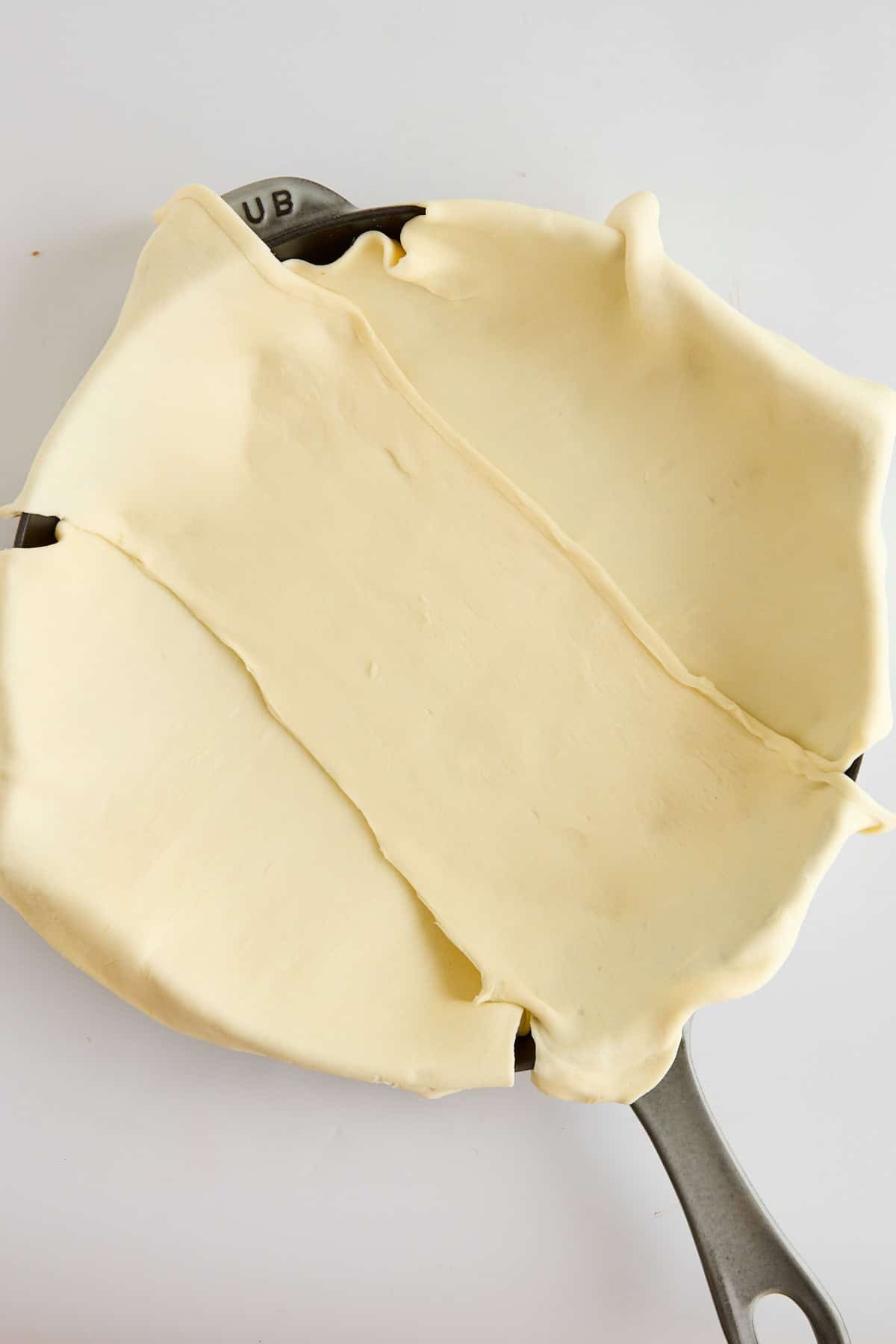 Puff pastry dough layered in a skillet.