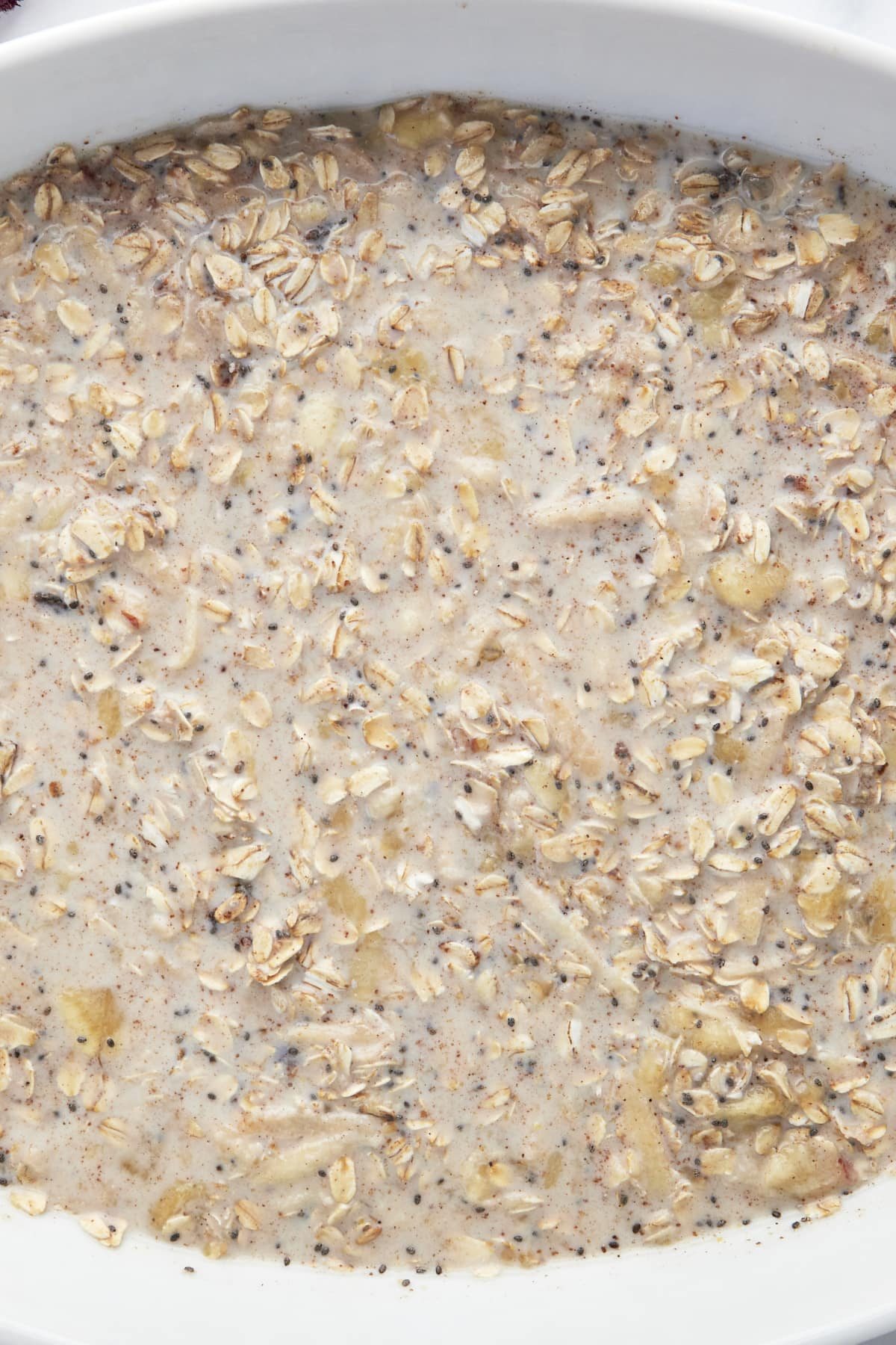Unbaked ingredients for baked apple oatmeal in a baking dish.
