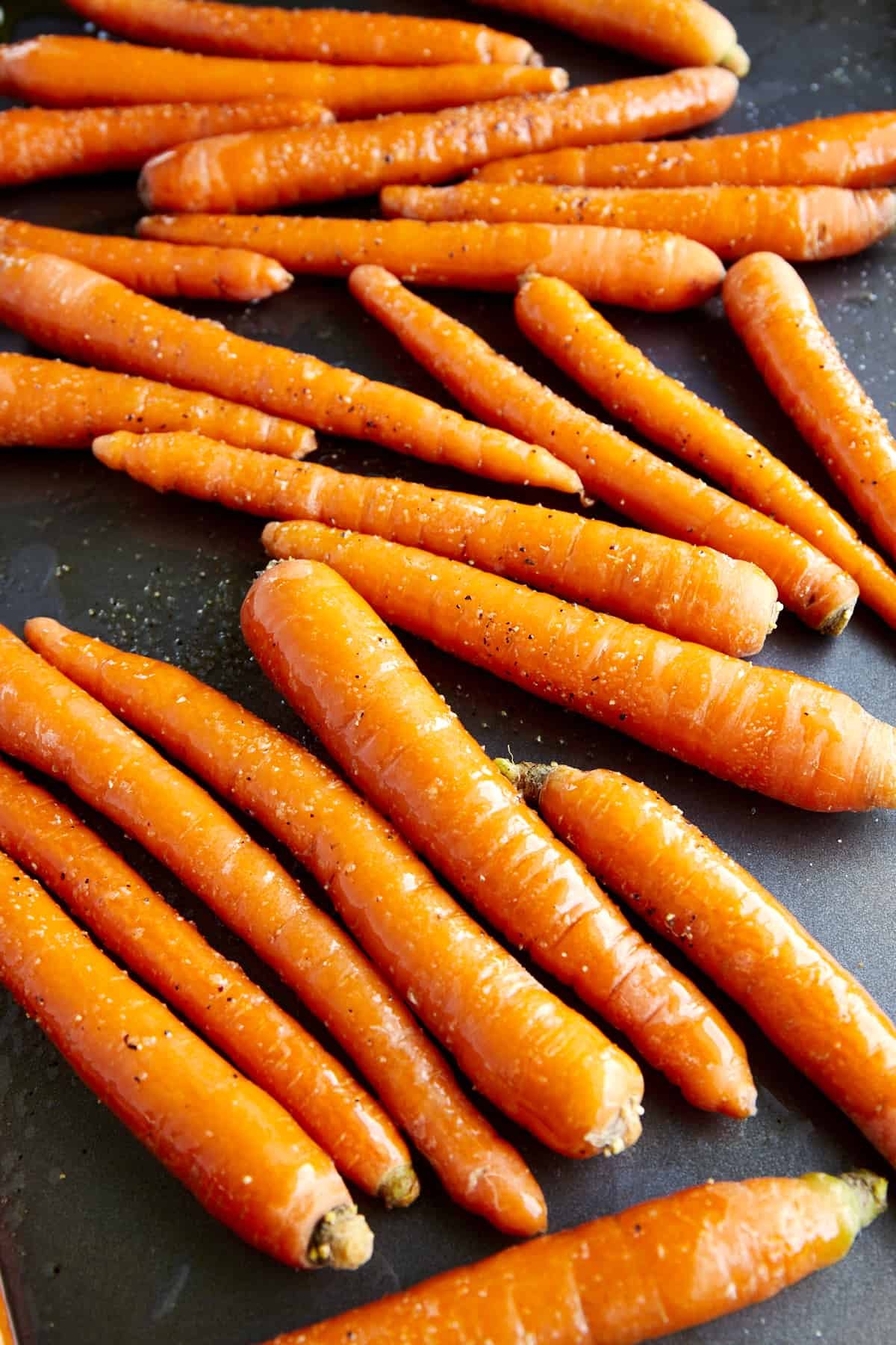 Unbaked carrots on a baking sheet.