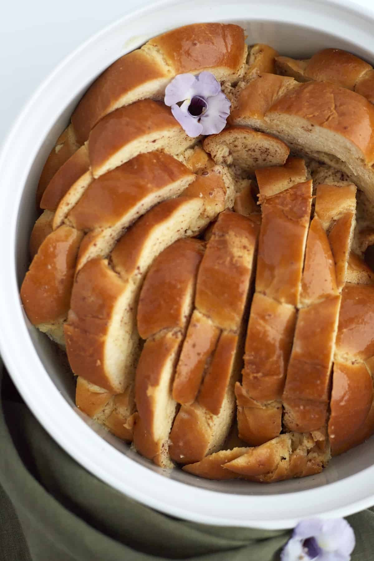 brioche bread layered upright in a baking dish