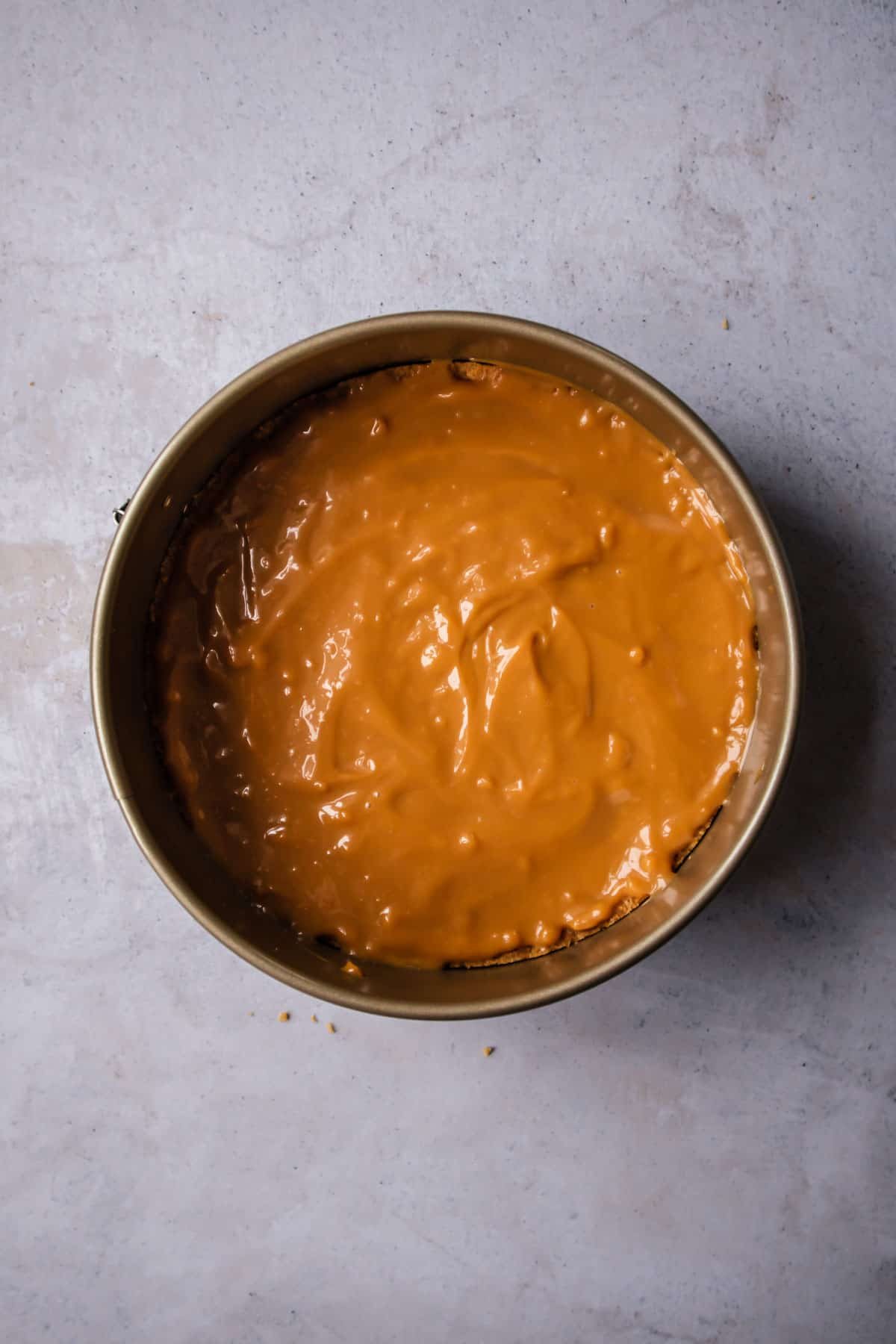 dulce de leche over a graham cracker crust in a pie pan