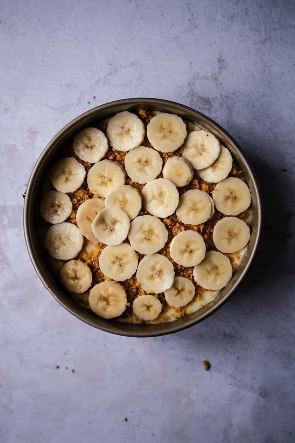 the second layer of bananas on top of graham cracker crumbs on a banofee pie