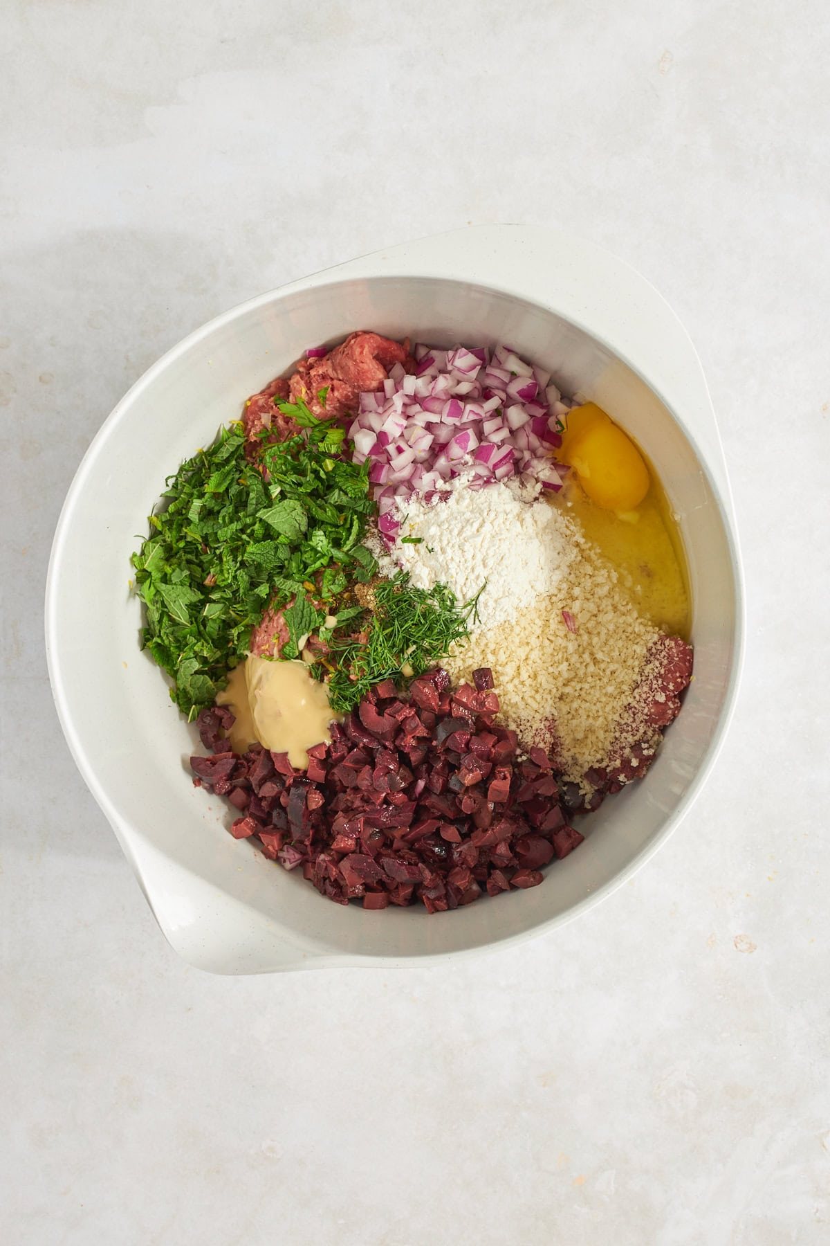 Ingredients for ground beef meatballs in a bowl.