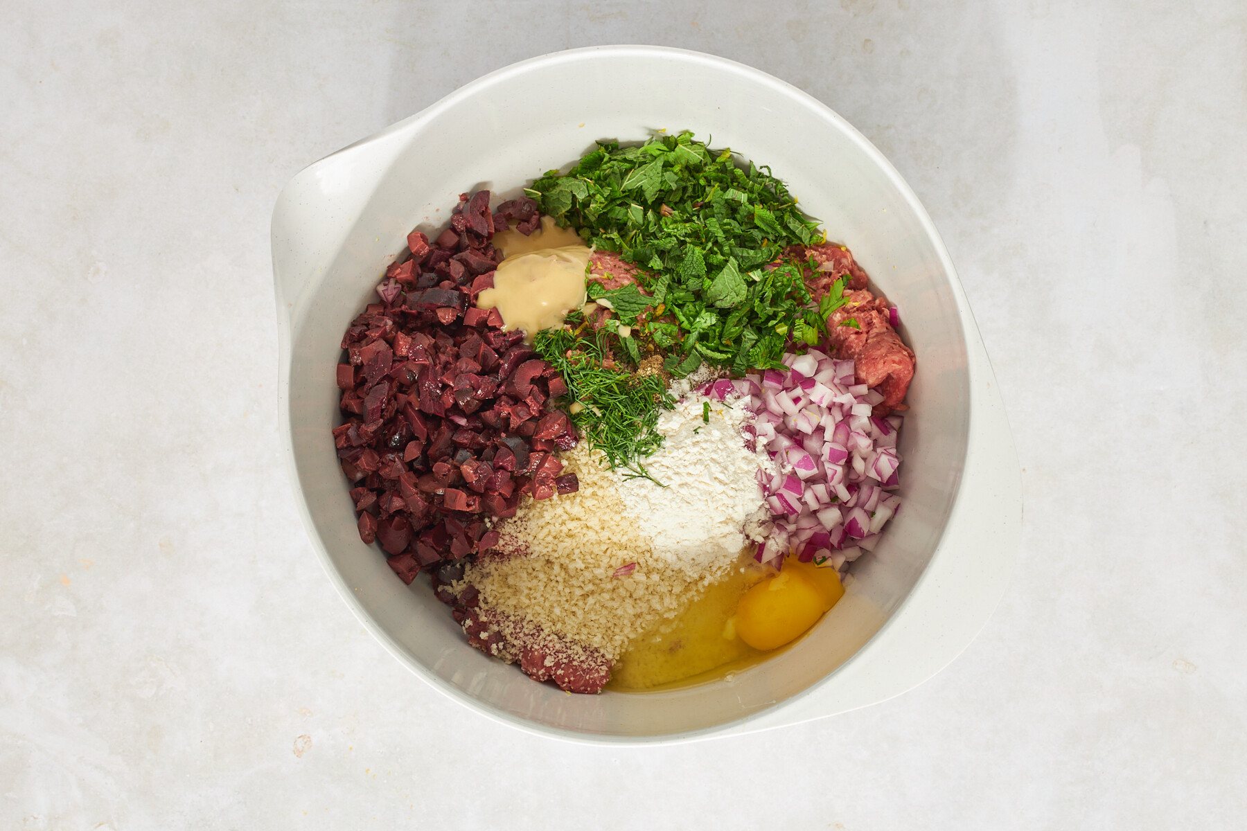 Mediterranean ground beef meatball ingredients in a bowl.