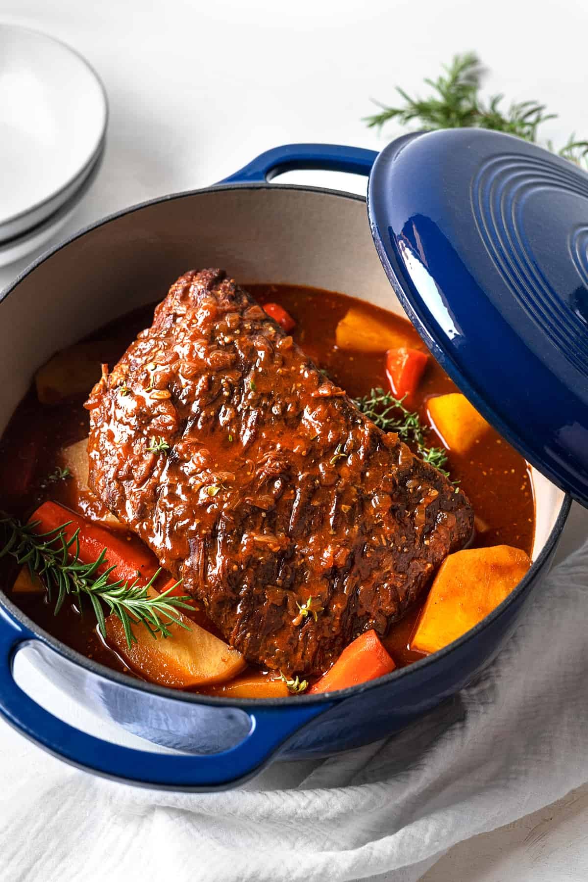 cooked beef pot roast in a dutch oven with potatoes and carrots.