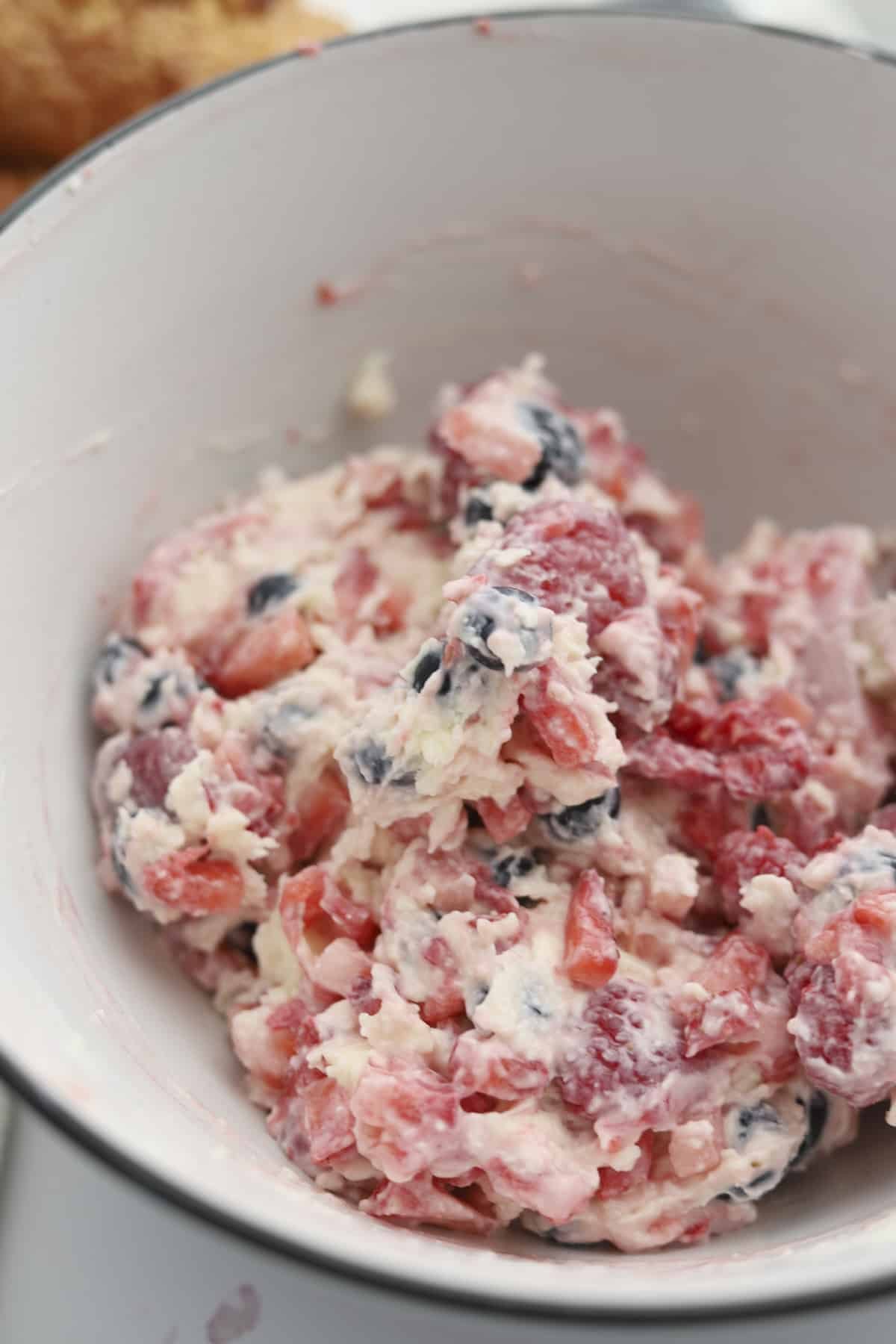 A bowl full of a berry cream cheese mixture to make berry stuffed croissant french toast