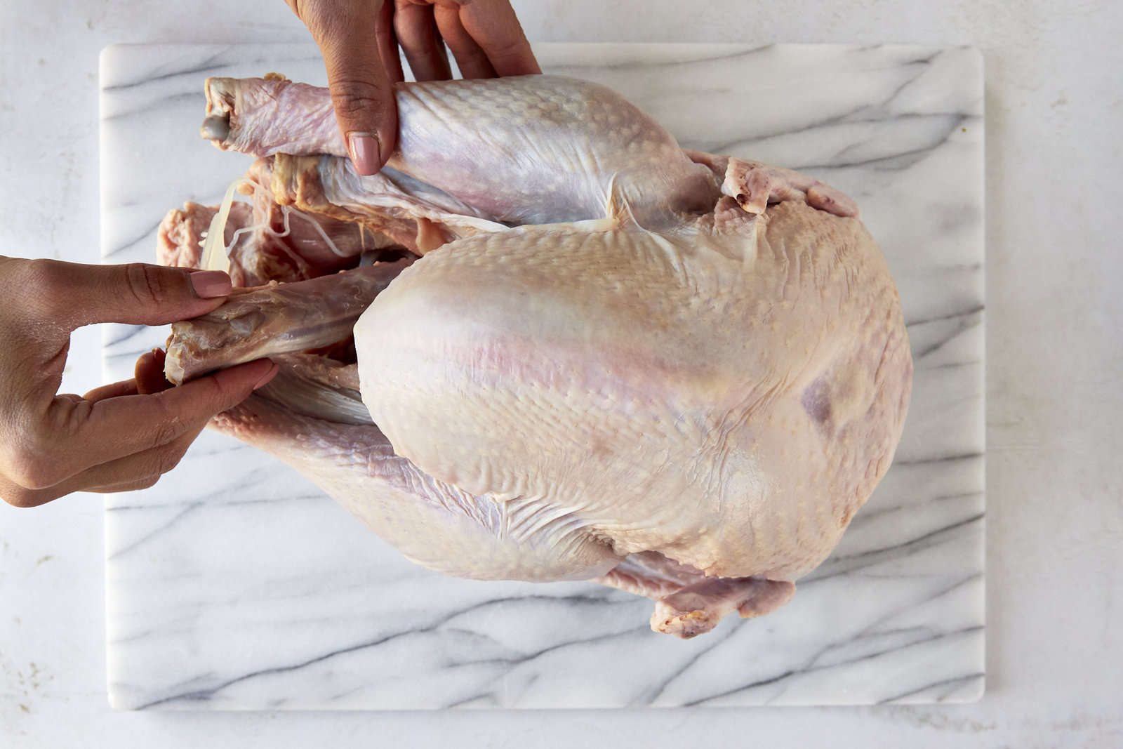 The neck and giblets being removed from a raw turkey.