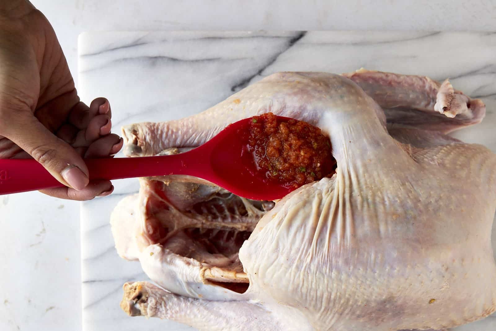 Turkey brine being spread under turkey skin.