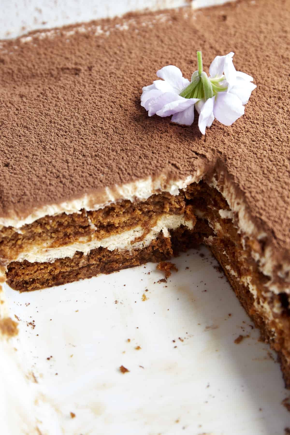 Biscoff tiramisu in a baking dish with a square missing.