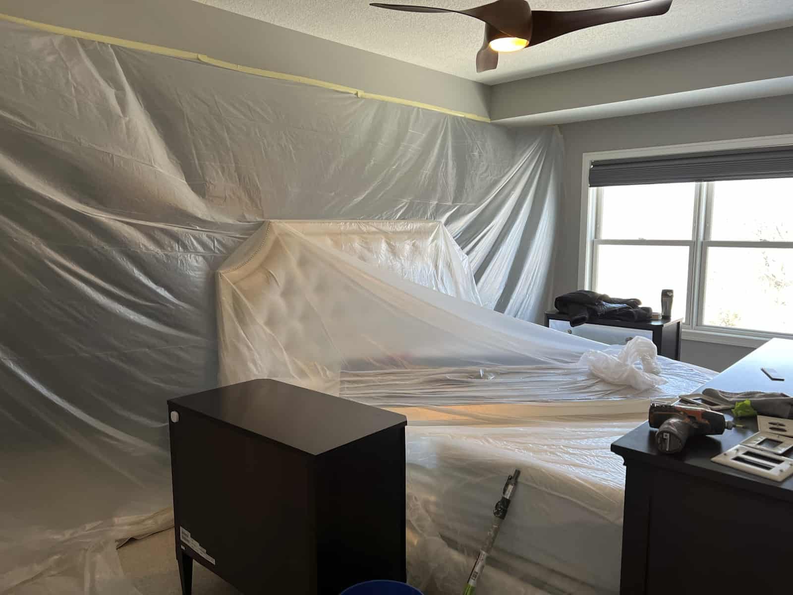 A bedroom covered with plastic before painting.