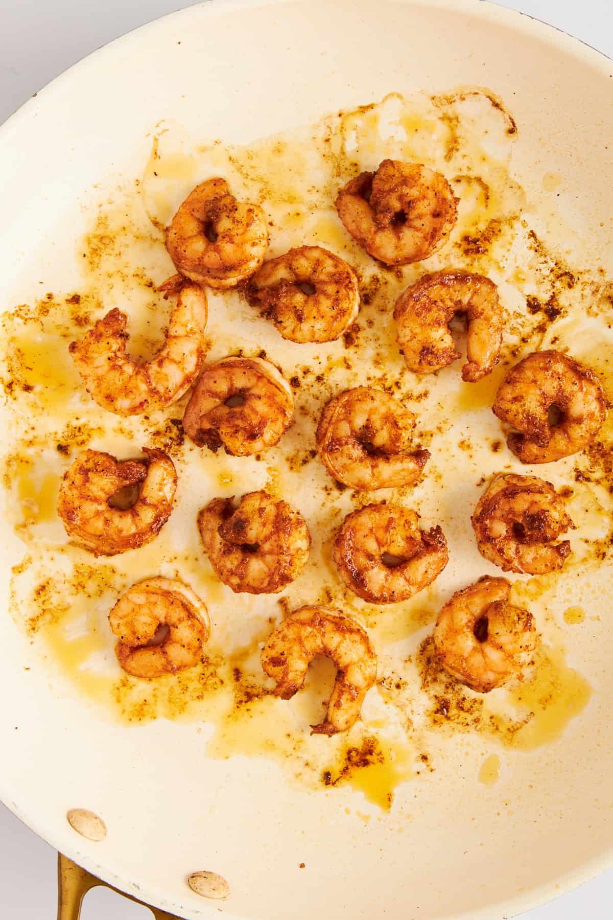 Blackened shrimp in a skillet.