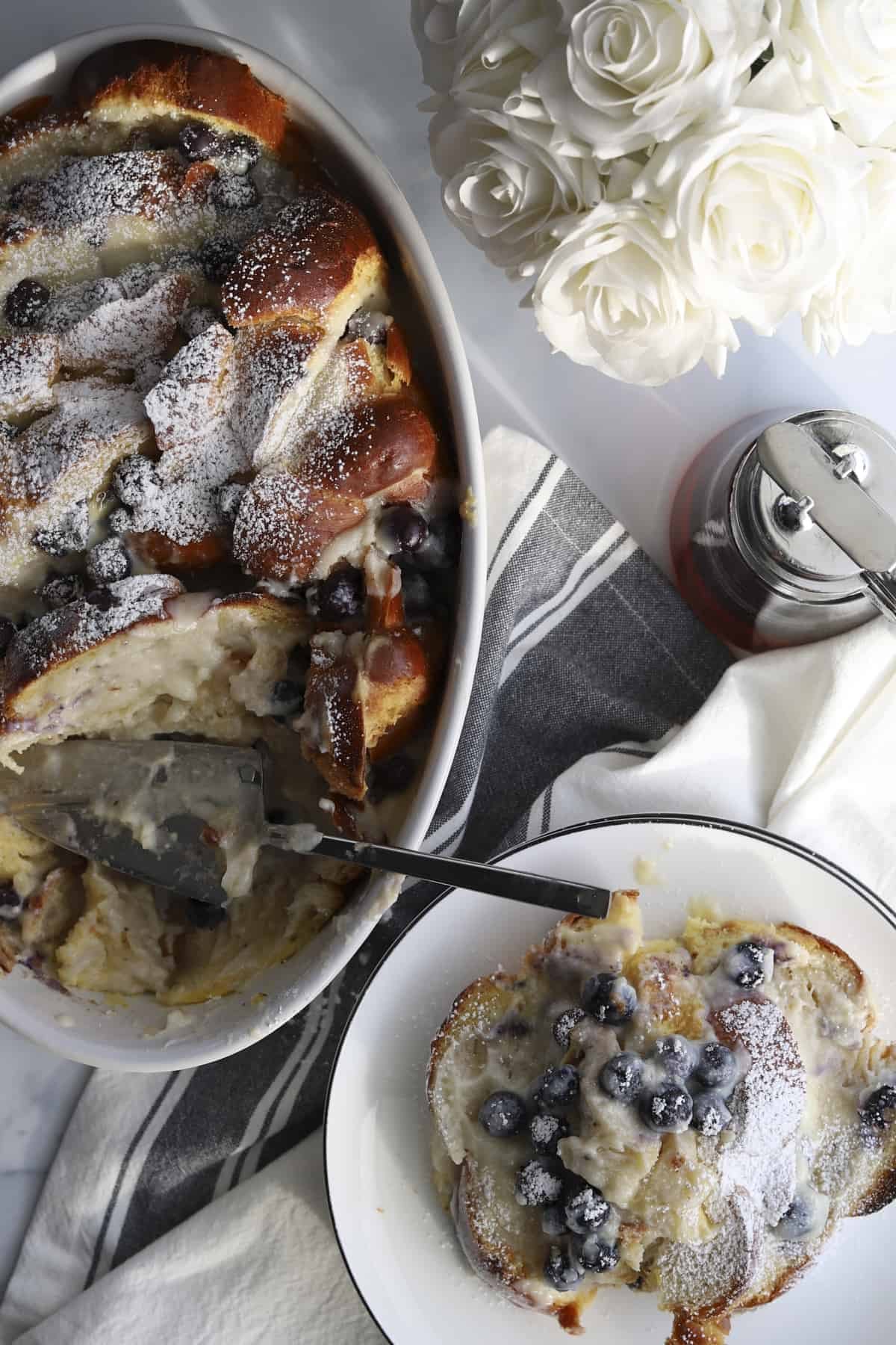 overhead blueberry mascarpone french toast baking dish and plated with powdered sugar