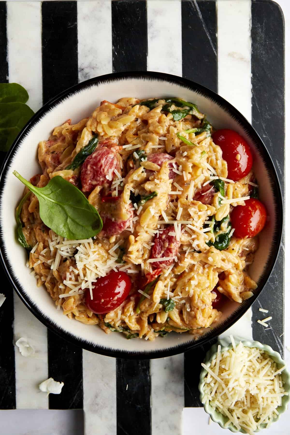 A bowl of pasta topped with parmesan cheese.