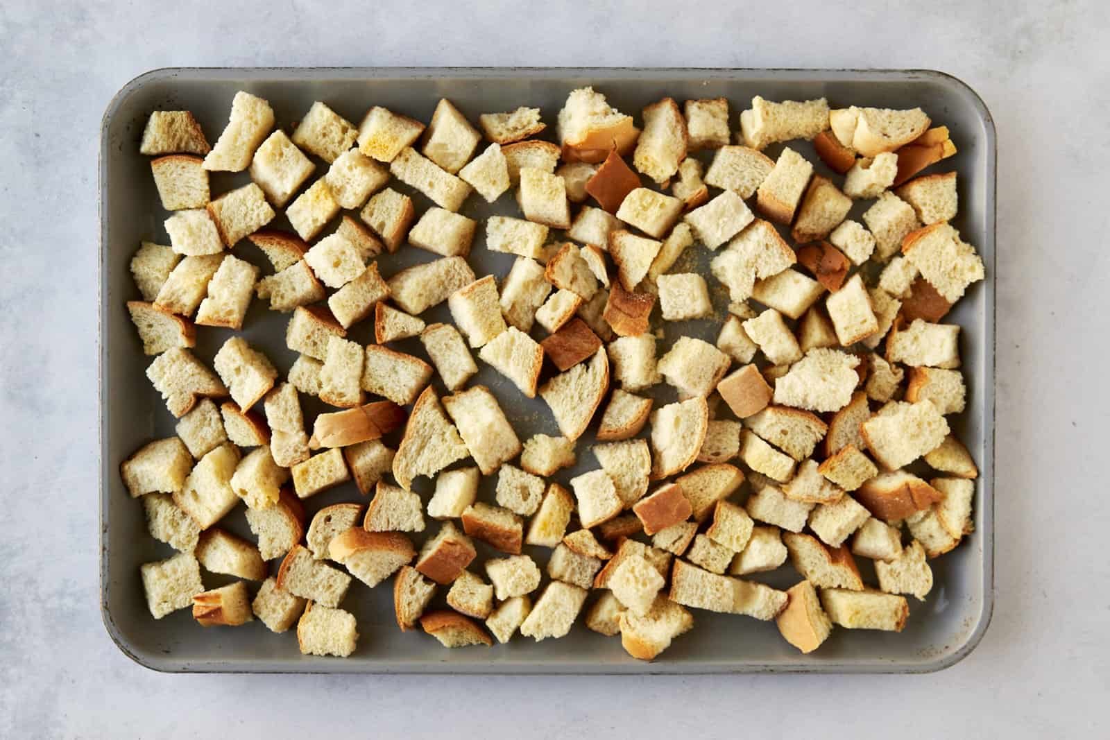 Bread cubes on a baking sheet.