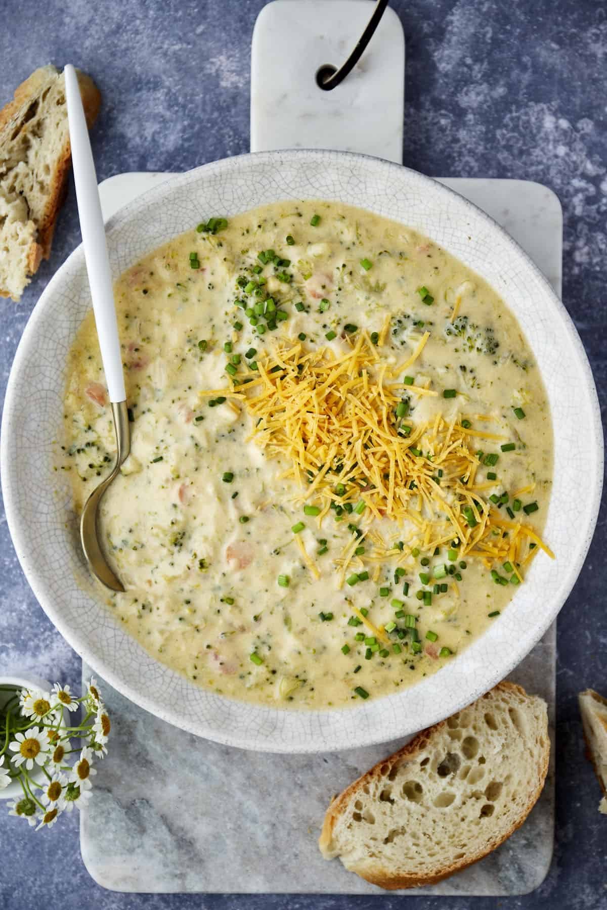 A bowl of broccoli and cheese soup with a spoon sticking out.