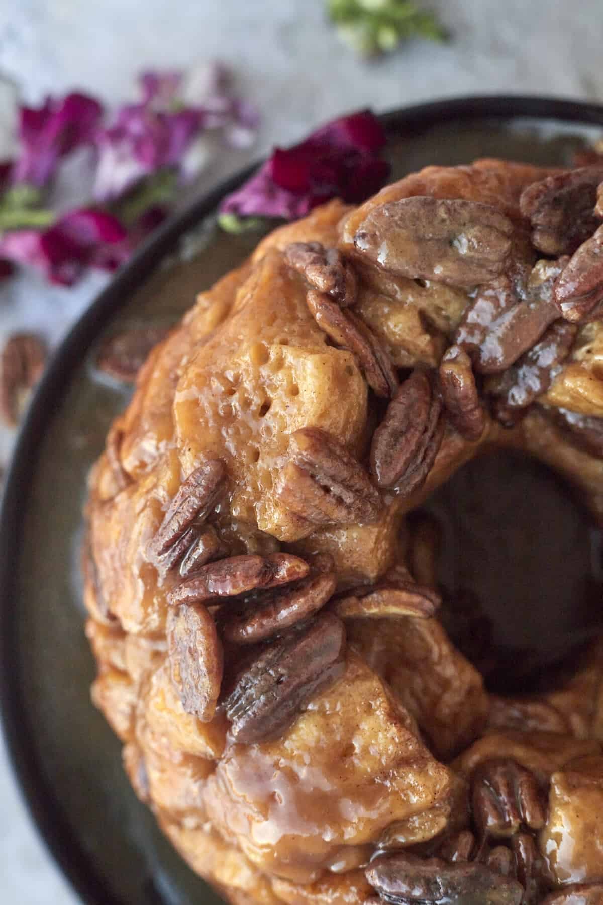 a ring of pecan caramel from-scratch monkey bread on a plate.