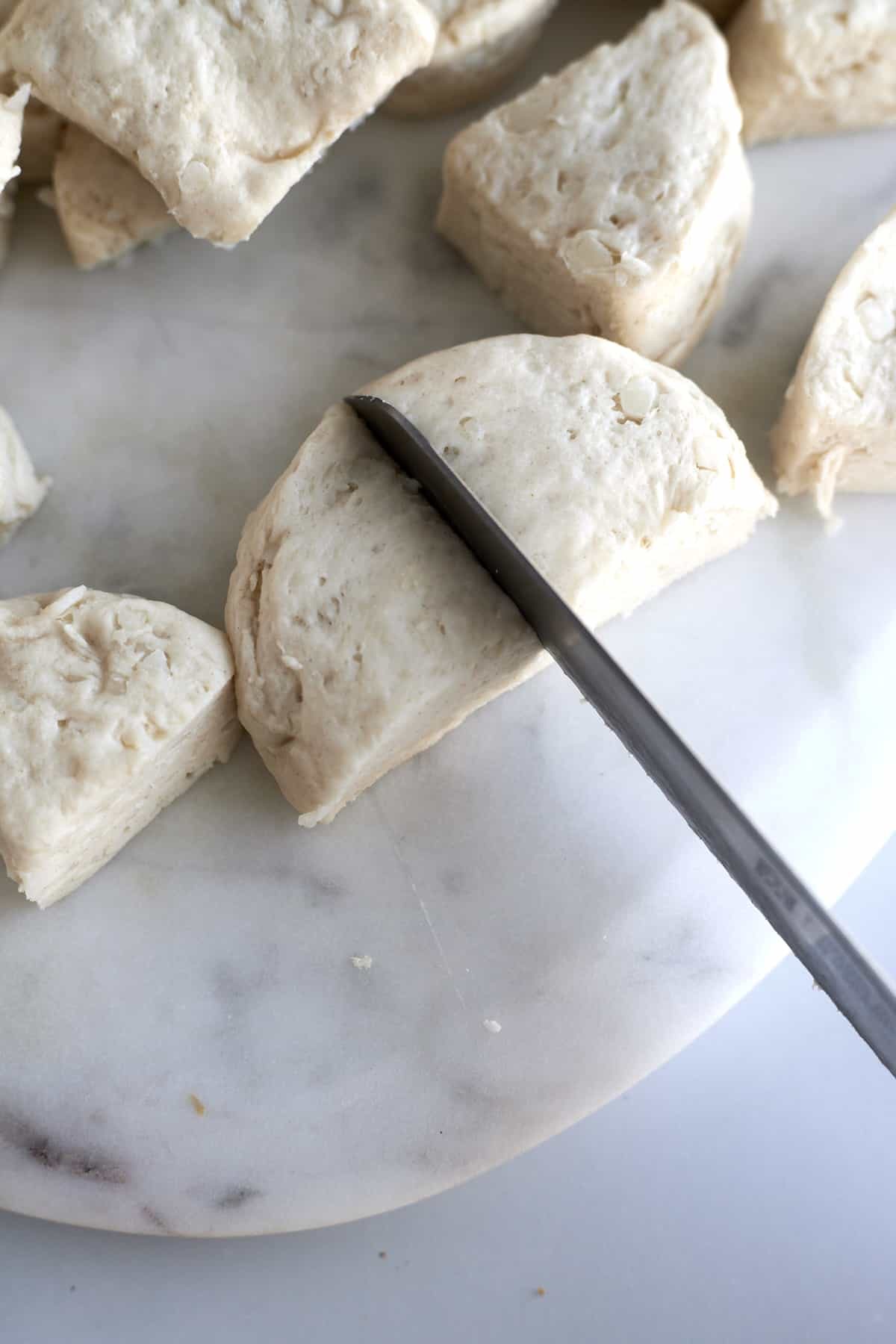 raw biscuits being quartered for monkey bread.
