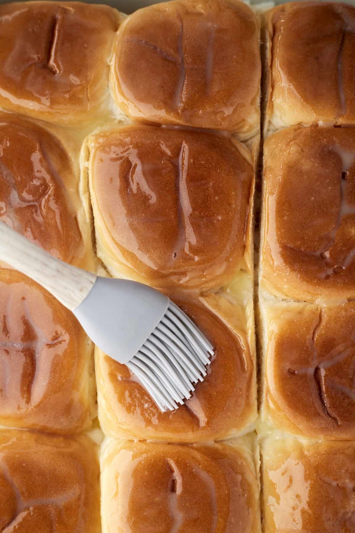 bread buns being brushed with butter