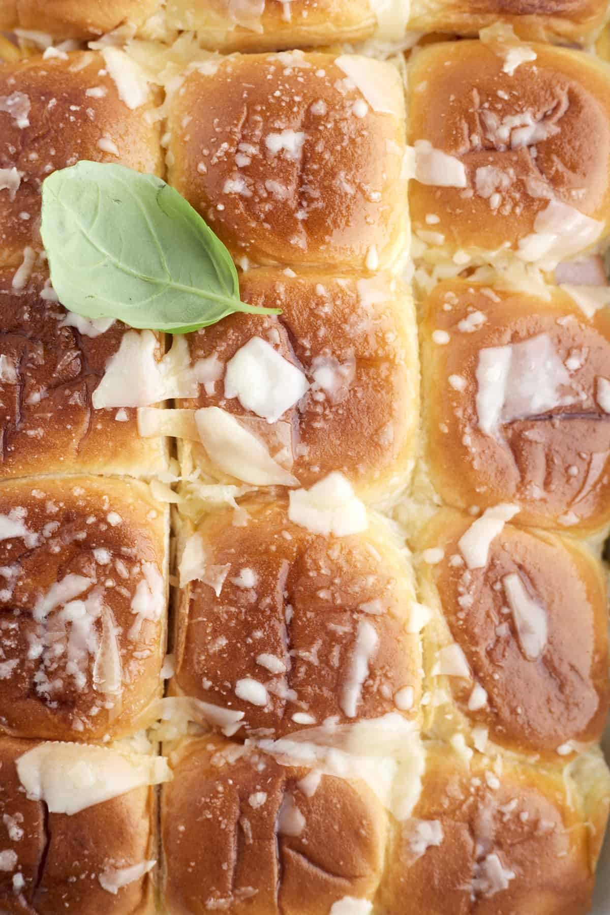 overhead image of baked cheesy breakfast brioche sliders topped with Parmesan