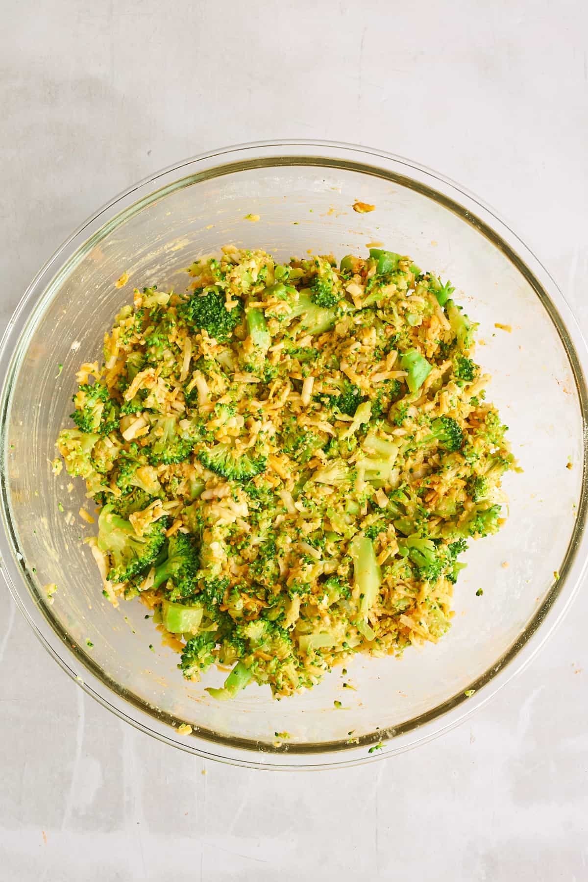 Cheesy broccoli fritters batter in a mixing bowl.