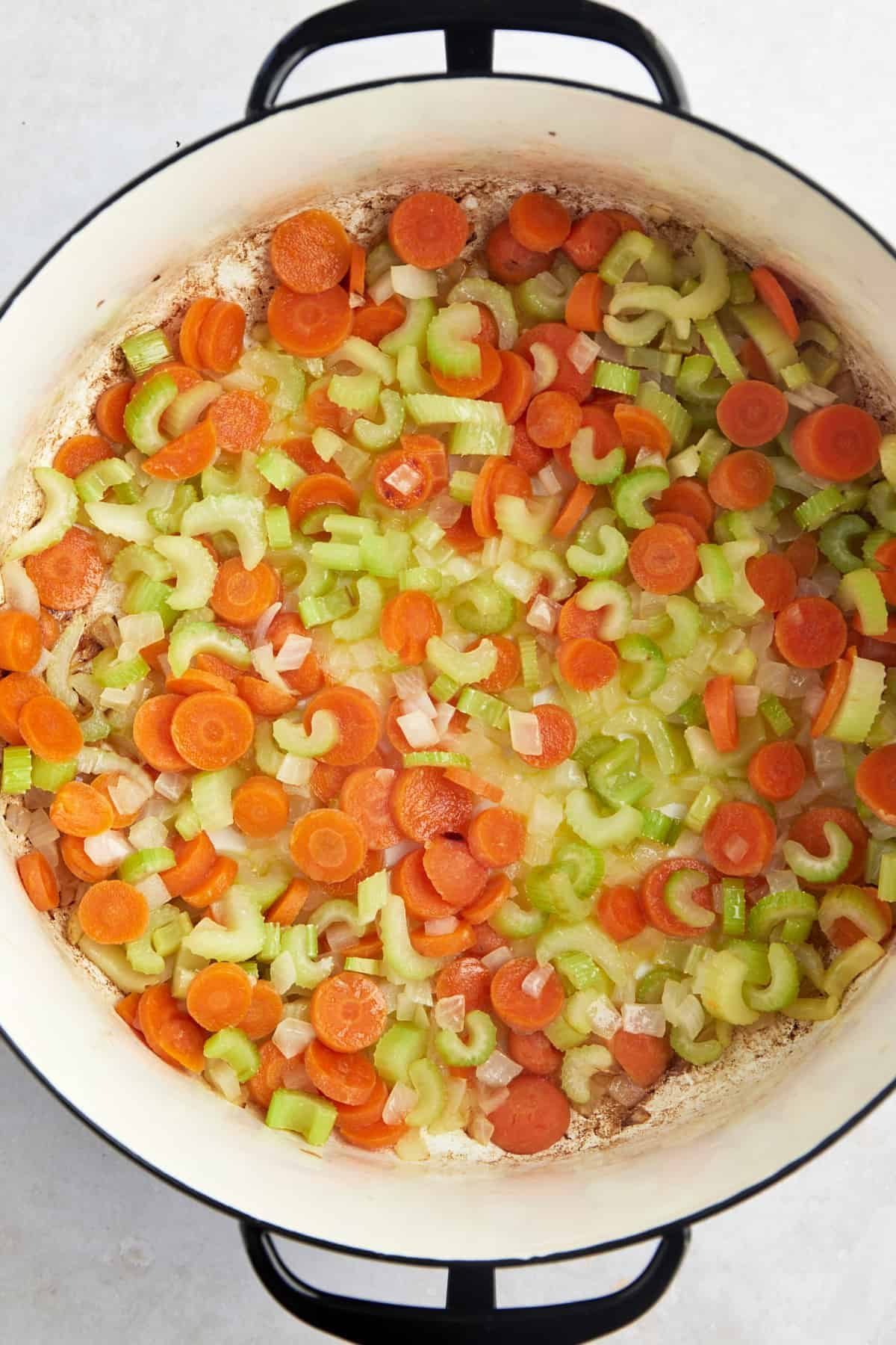Chopped carrots, onions, and celery in a soup pot with butter and oil.
