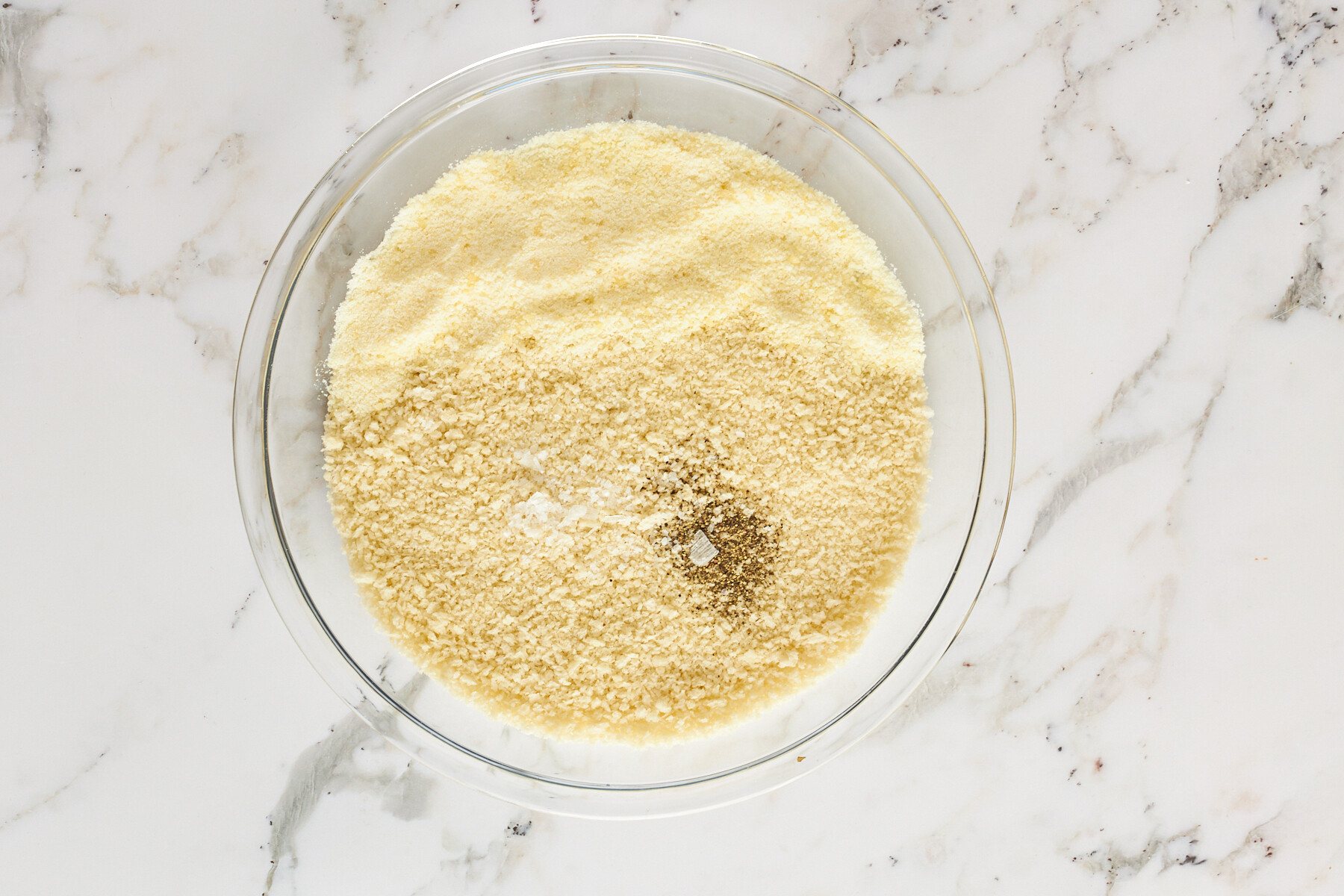 A bowl of breadcrumbs, seasonings, and cheese.