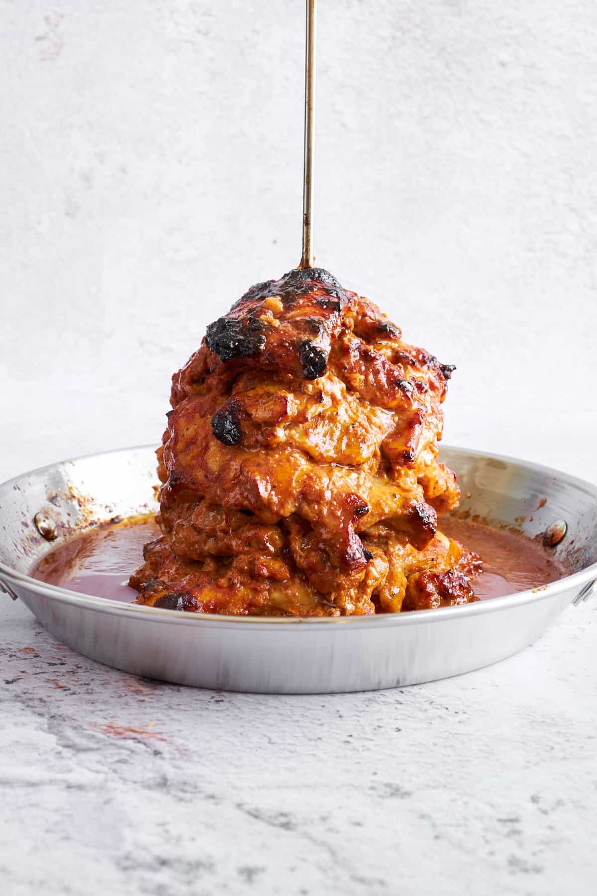 Baked chicken shawarma on a vertical spit.