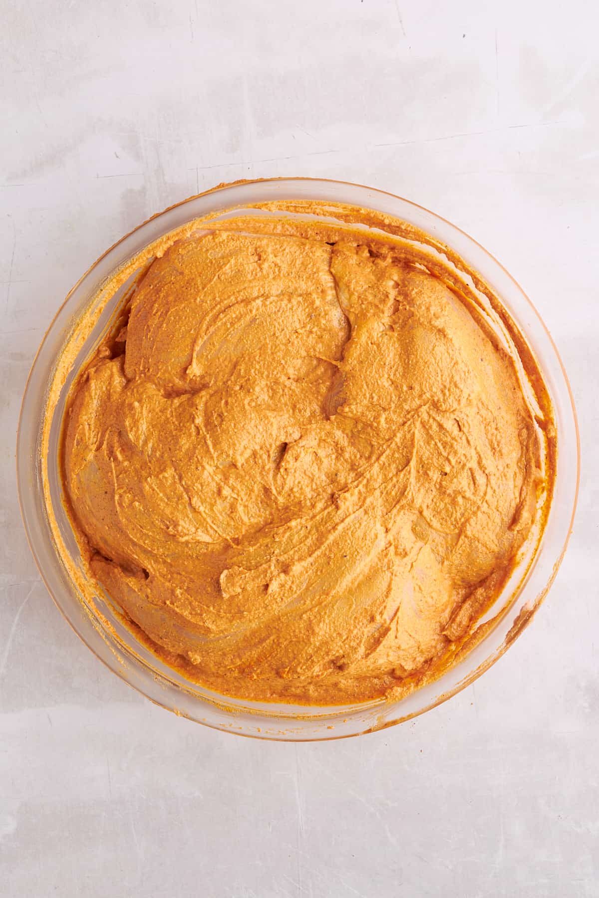 Chicken breasts in a bowl coated in shawarma marinade.