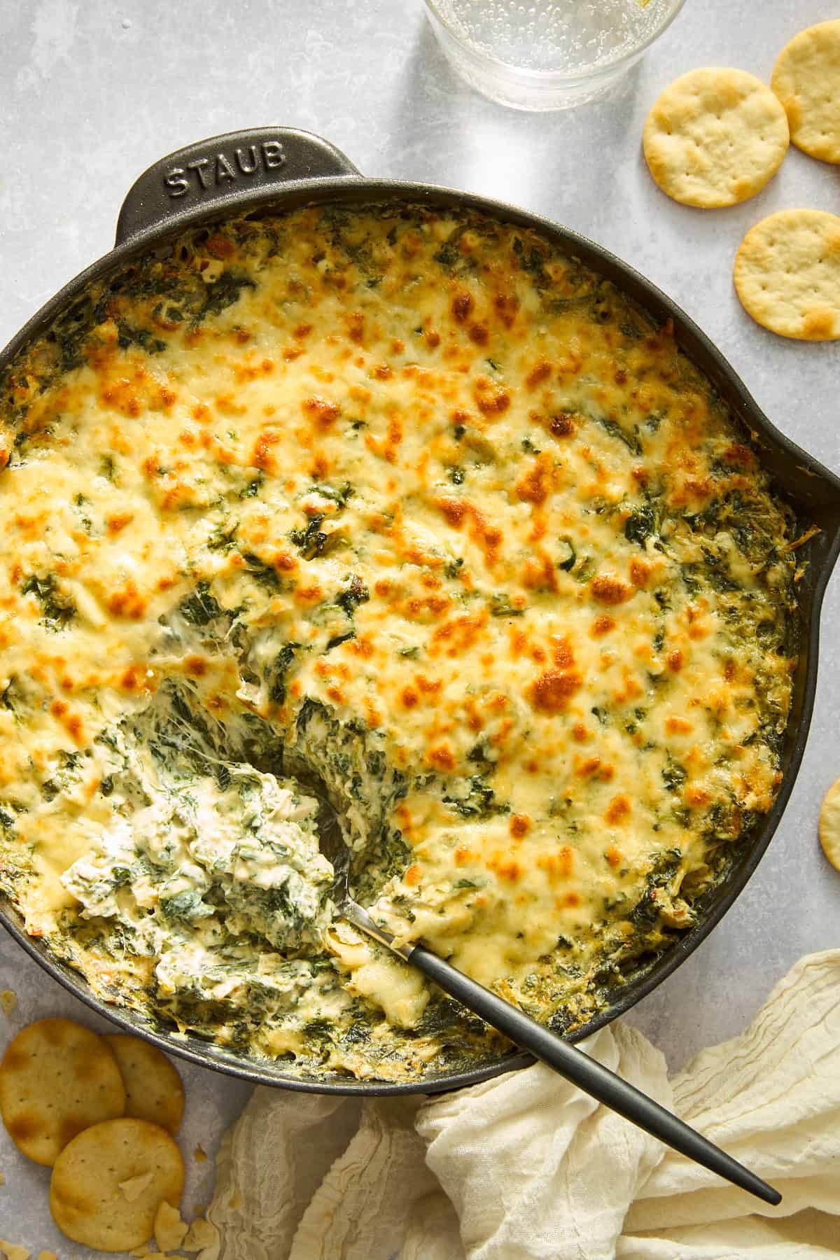 A skillet of silky chicken spinach and artichoke dip.