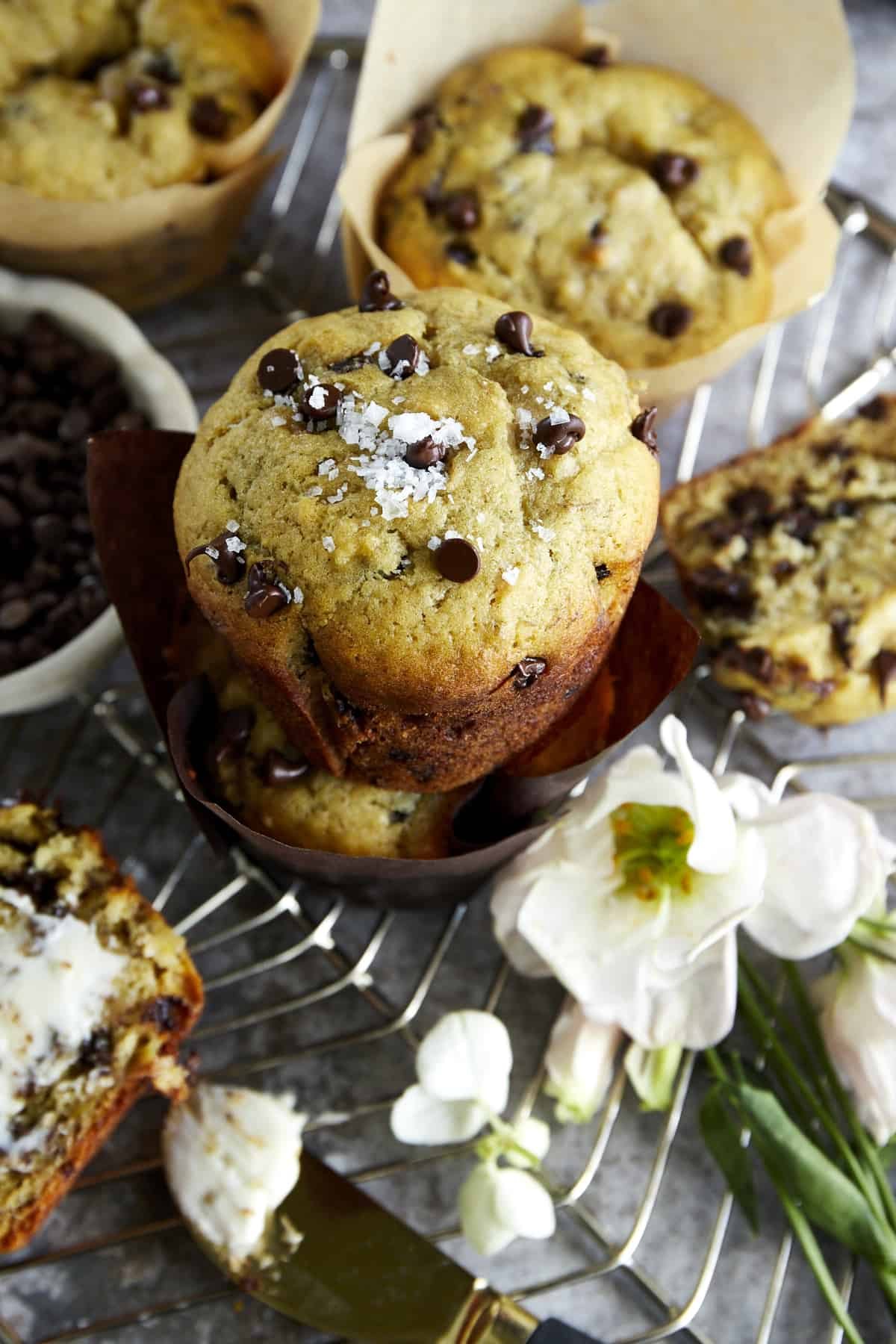 Chocolate chip banana bread muffins on a wire rack topped with sea salt flakes.