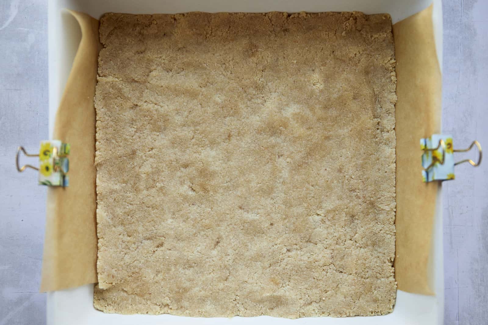 Almond flour crust pressed into a baking dish.