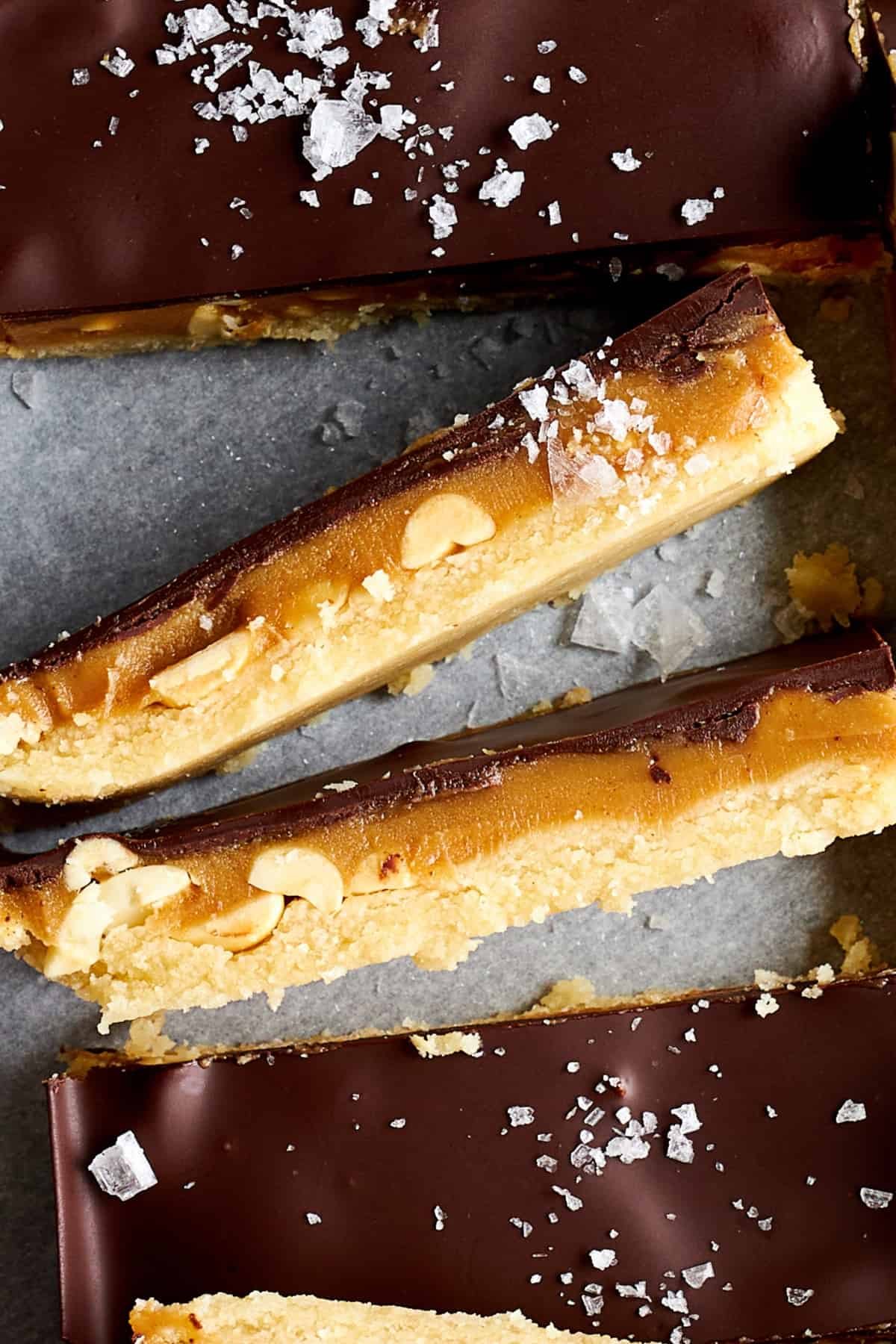 Side view of homemade Snickers bars showing the different layers.