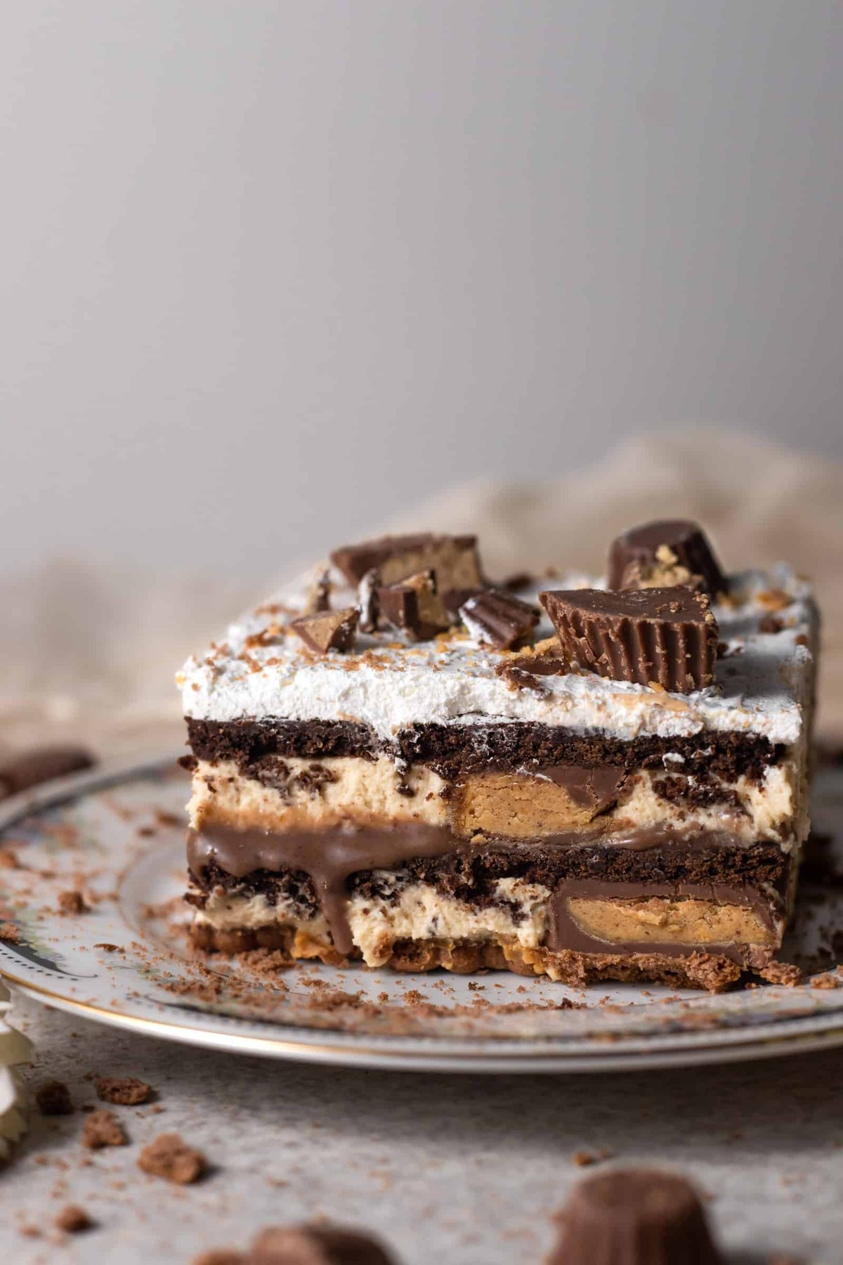 a slice of chocolate peanut butter lasagna topped with chopped Reese's cups