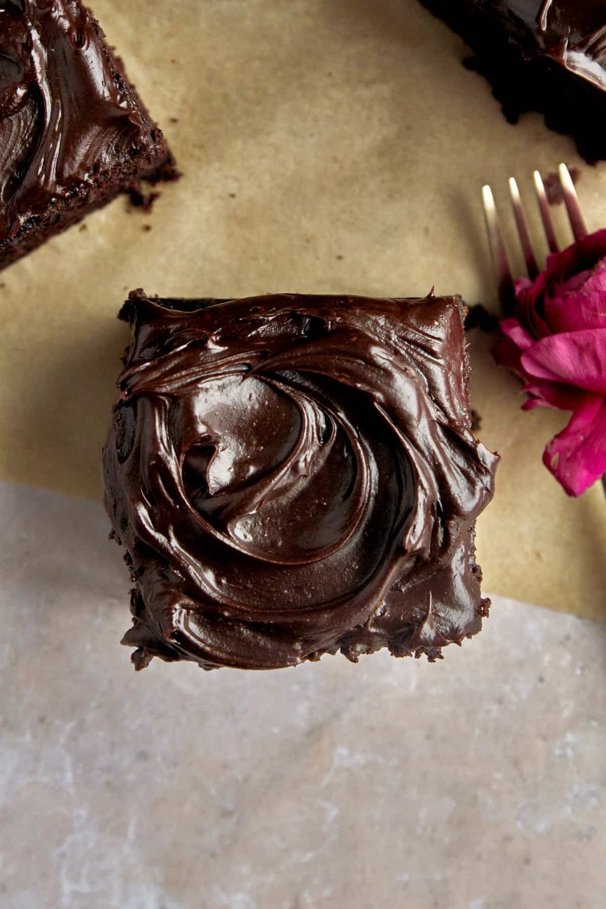 Overhead image of chocolate frosting on top of a square of zucchini cake.