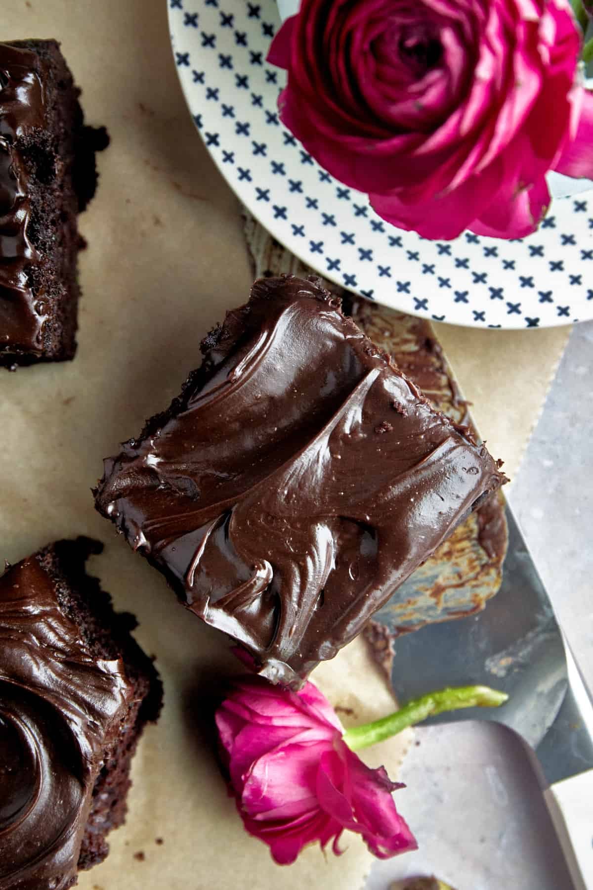 Overhead image of a square of chocolate zucchini cake topped with chocolate frosting.