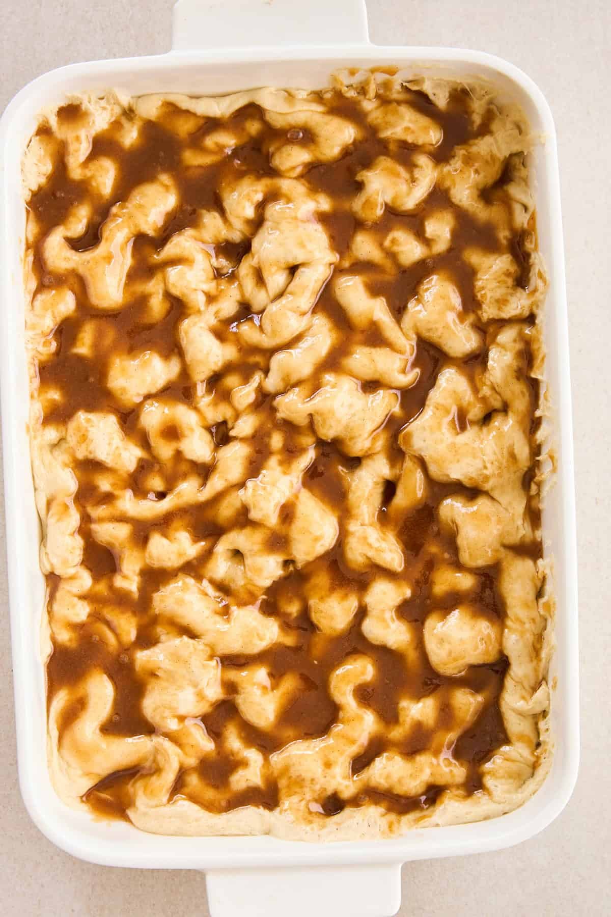 Brown sugar and butter topping over raw dough in a baking dish.