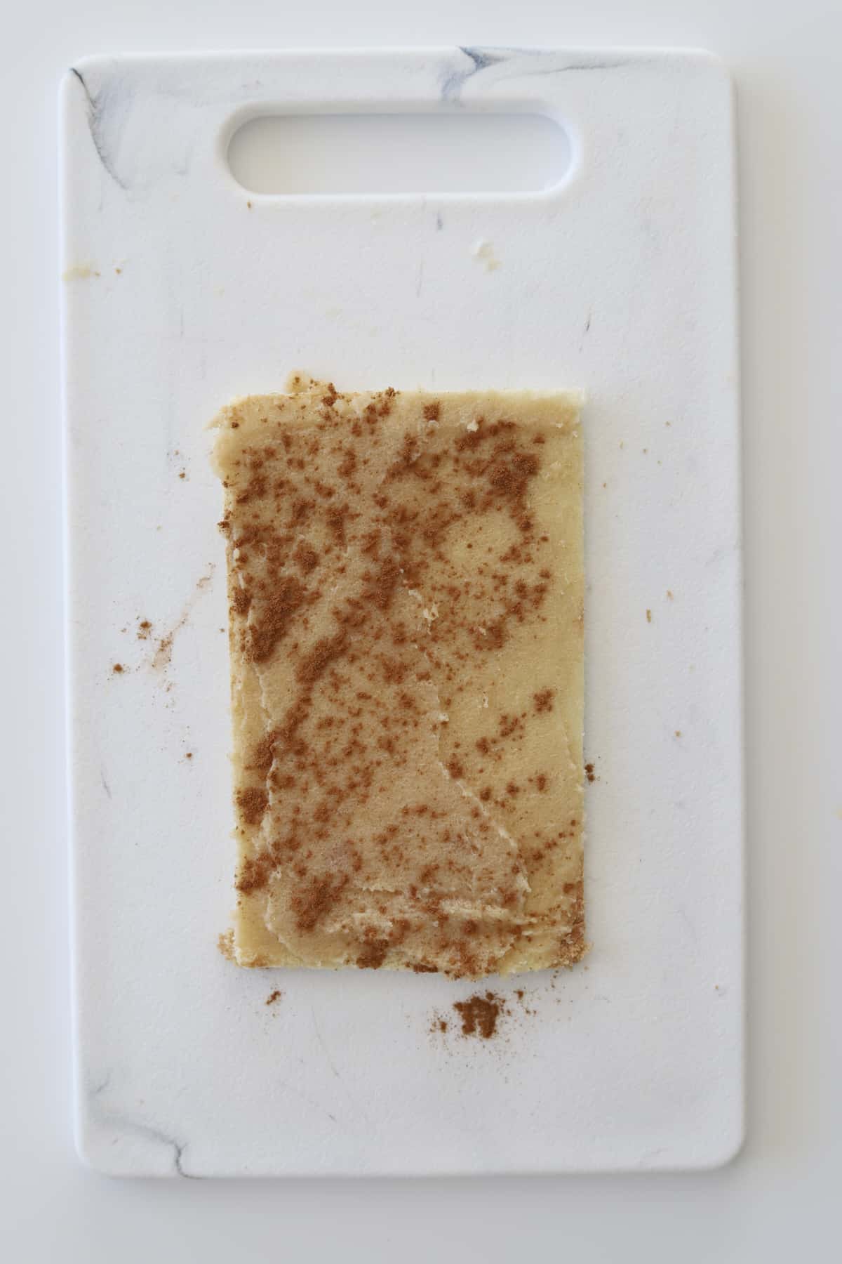 a flattened piece of bread topped with a cinnamon sugar mixture