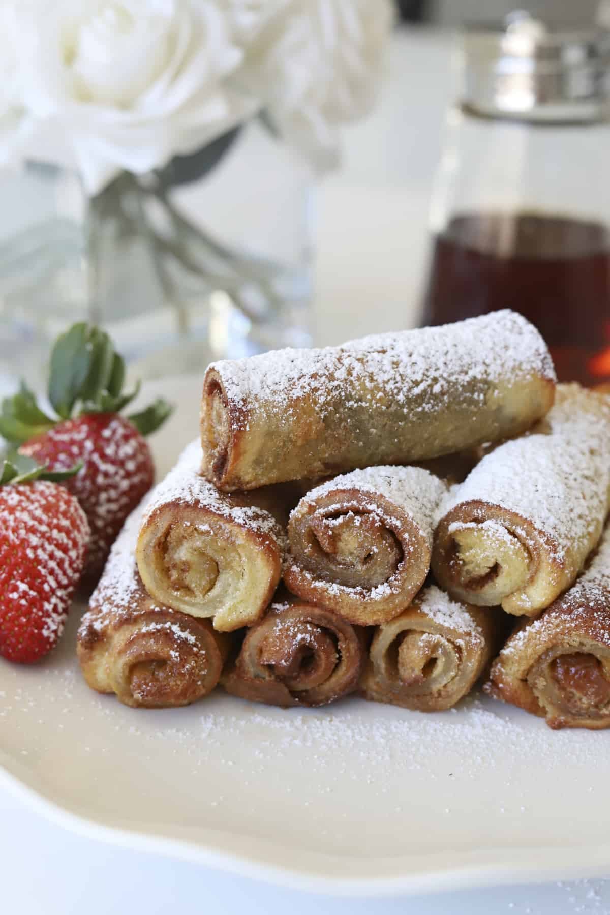 plate of cinnamon roll french toast with strawberries